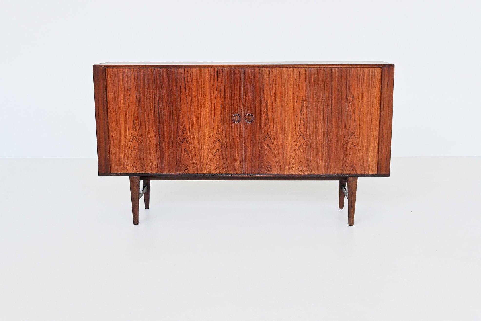 Beautiful Danish highboard designed by Harry Østergaard for Randers Møbelfabrik, Denmark 1960. This cabinet is a testament to Danish craftsmanship and innovative design. Known for his dedication to both functionality and aesthetics, Østergaard