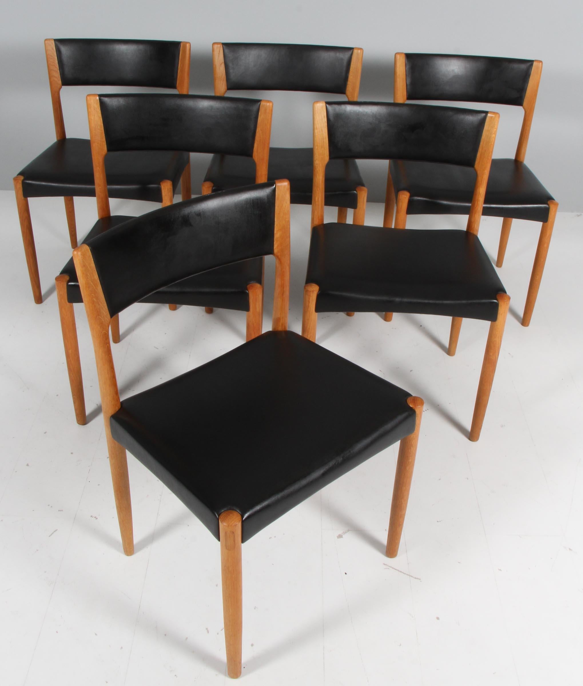 Harry Ostergaard set of six dining chairs in oak.

Seats and back original upholstered with black.

Made by Randers Møbelfabrik.