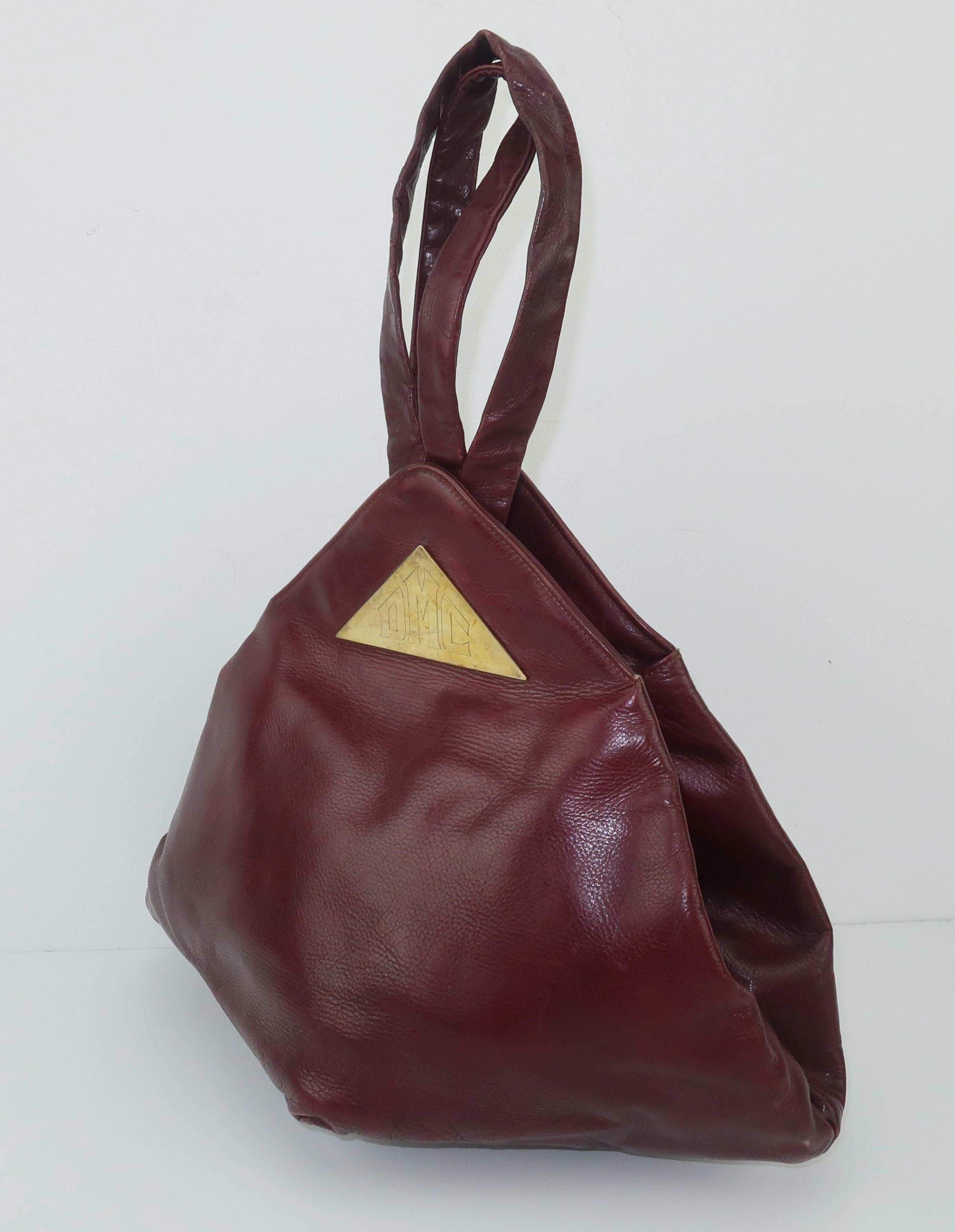 Depending on the angle, this C.1940 Harry Rosenfeld design looks like a triangle, a diamond or a hexagon ... from the sides, bottom and opening.  A closer look reveals that the oxblood color leather has a simple folded construction that works