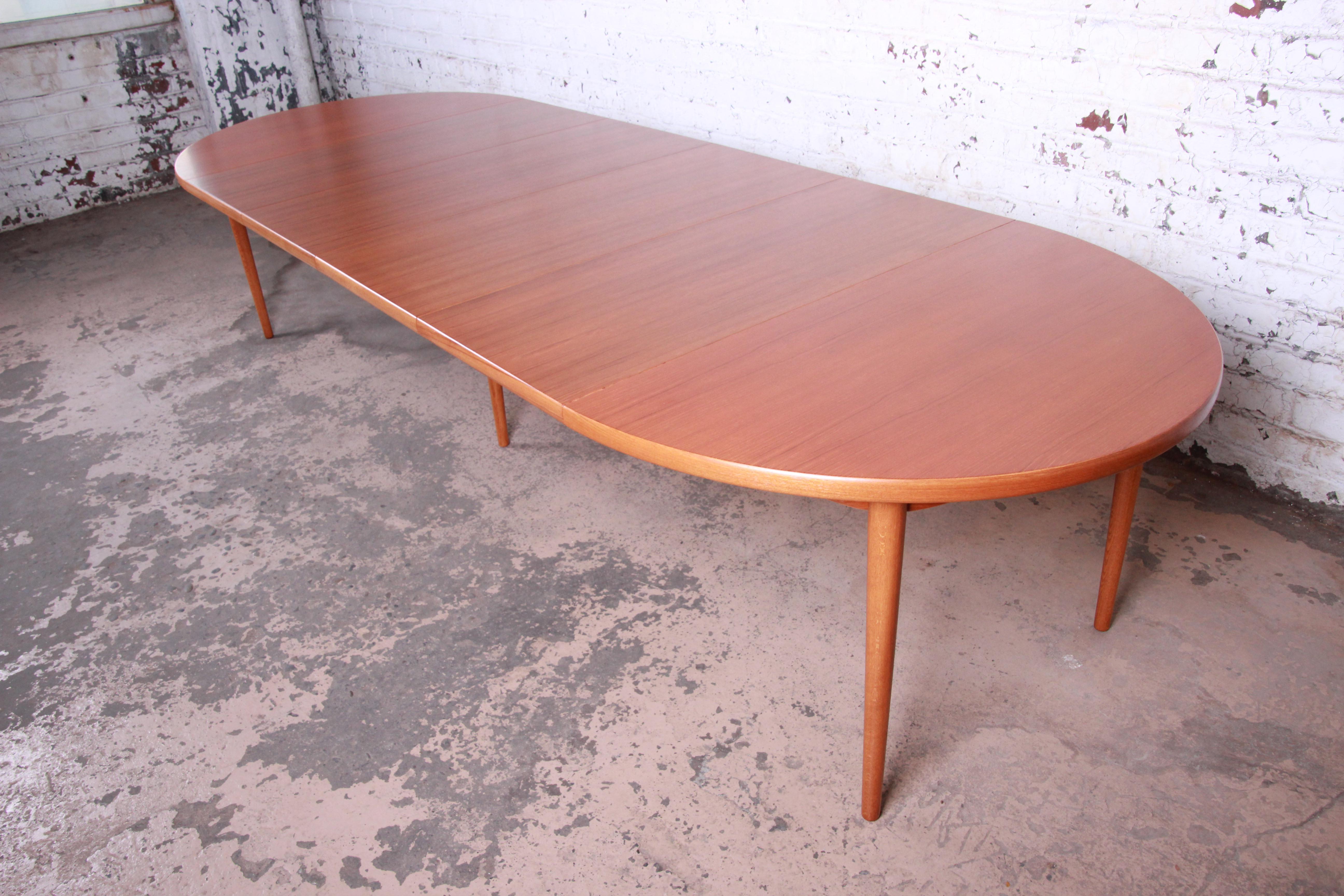 An outstanding midcentury Swedish modern teak extension dining table by Harry Østergaard for Moreddi. The table features gorgeous teak wood grain and sleek Scandinavian design. It is extremely versatile with four large leaves that can extend the