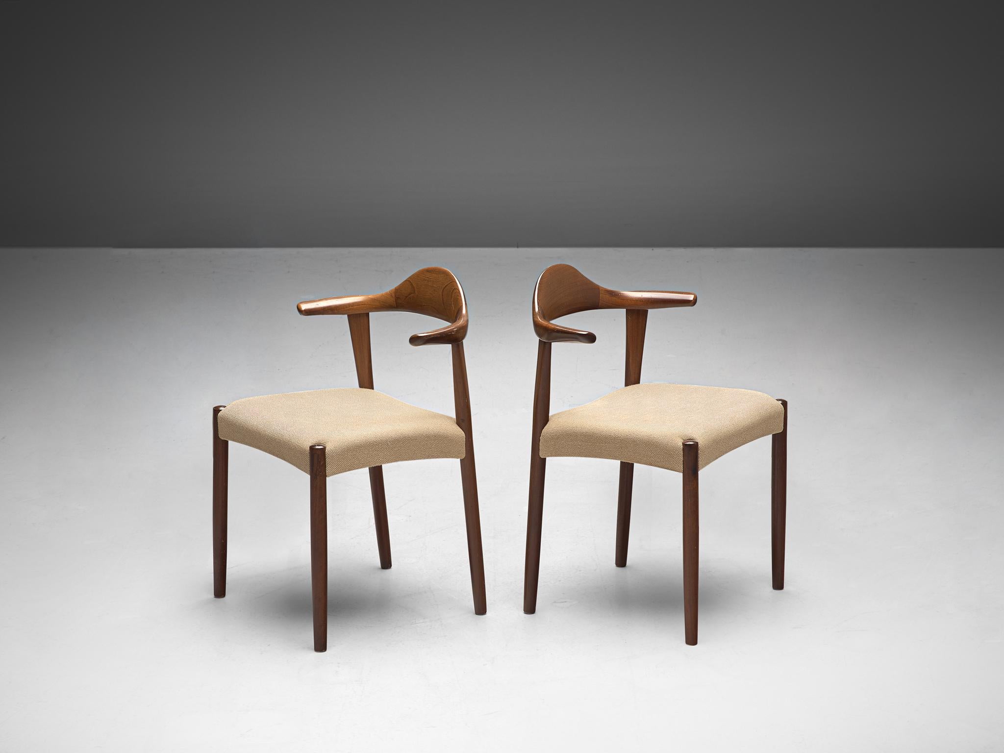 Harry Østergaard for Randers Møbelfabrik, pair of 'Bull Horn' chairs, teak, fabric 1950s.

This dining chair of Danish origin owes its name to the armrests that are based on the shape of a bull horn. The wooden frame illustrates a dynamic