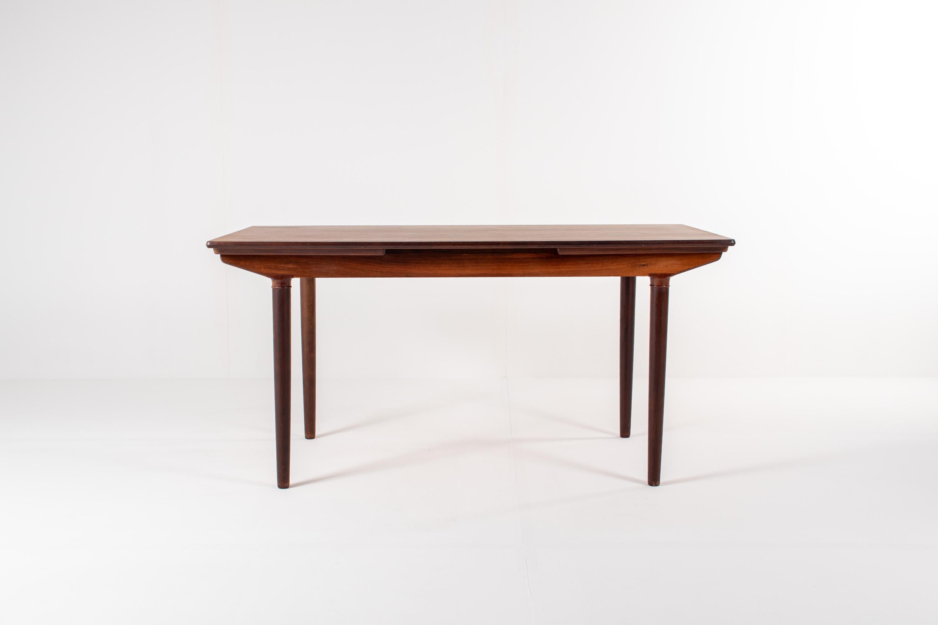 Découvrez cette exceptionnelle table de salle à manger extensible en bois de rose conçue par Harry Elegaard dans les années 1960 - un exemple élégant de l'artisanat danois du milieu du siècle. La table présente un plateau en bois de rose
