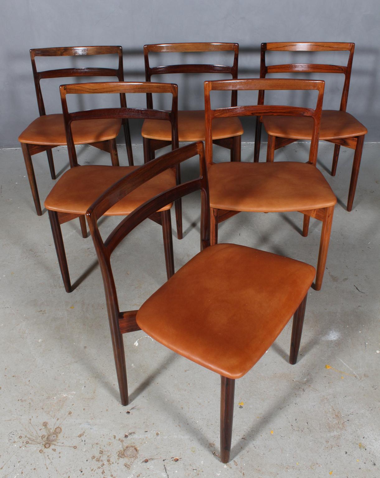 Harry Ostergaard set of six dining chairs in rosewood.

Seats new upholstered with tan aniline leather.

Made by Randers Møbelfabrik.