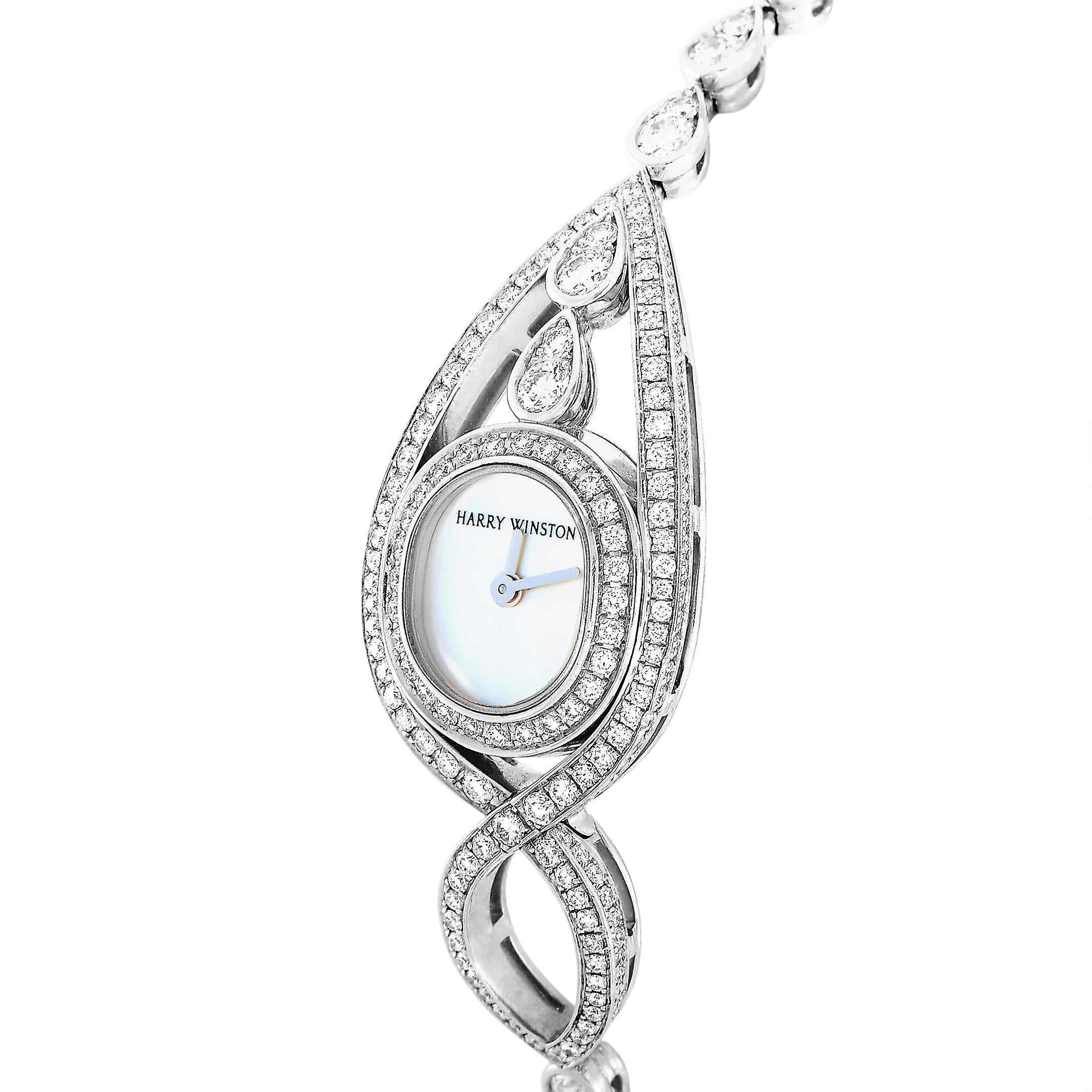 This Harry Winston timepiece is made out of 18K white gold and embellished with diamonds that boast E color and VVS clarity and total approximately 4.00 carats. The watch is powered by a quartz movement and on the 18mm mother of pearl dial indicates