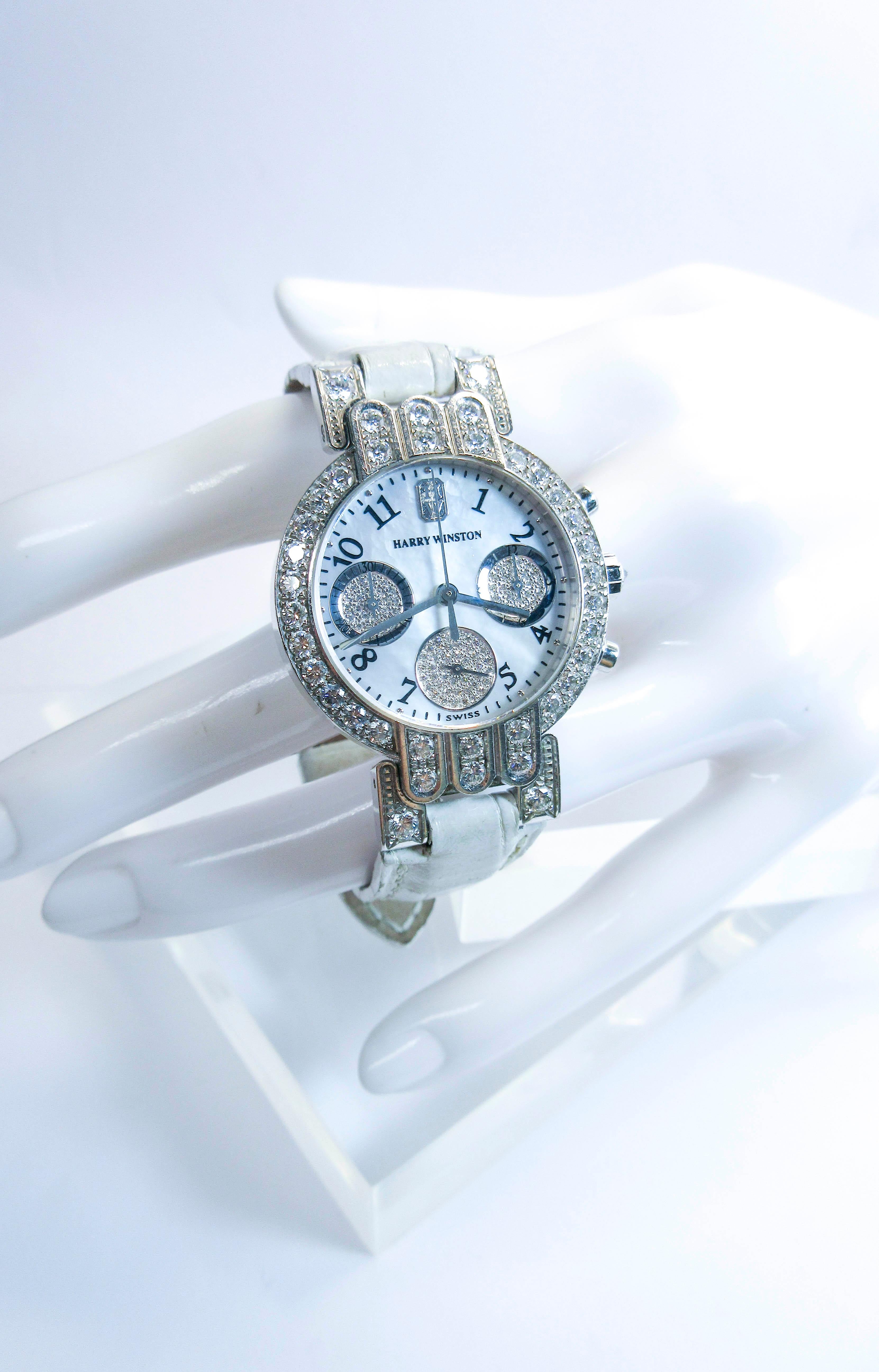This Harry Winston watch is composed of 18KT white gold with pave diamond accents and a Mother of Pearl face. Comes with a white exotic alligator band. 
The watch is battery operated.

Please feel free to ask us any additional questions you may