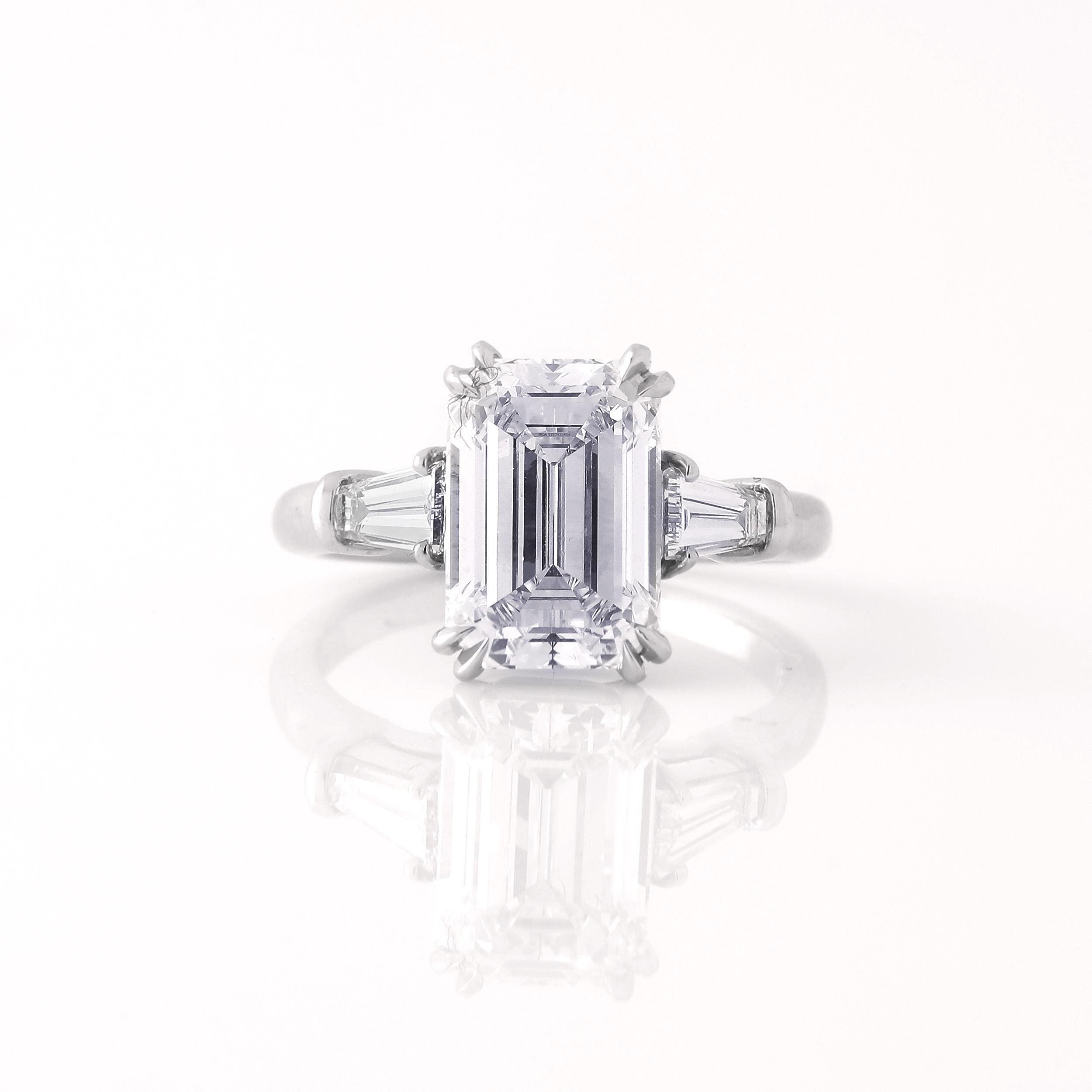 Harry Winston 3.06 ct E VVS2 Emerald Cut Three Stone Diamond Engagement ring with Tapered Baguettes weighing 0.49 cts mounted in Platinum. Emerald Cut Center Diamond is GIA Certified and measures 9.99 x 6.91 x 4.67mm. Includes original box, papers,
