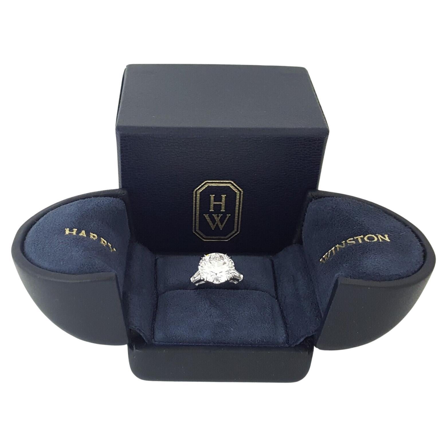 Introducing the timeless elegance of the Harry Winston 4.49 ct Total Weight Round Brilliant Cut with Tapered Baguette Diamond Platinum Engagement Ring. Crafted to perfection, this exquisite piece weighs 5 grams and is sized at 6.

At its heart lies
