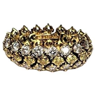 Stunning yellow and white diamonds encircle this 18 karat yellow gold flexible ring by famed designer Harry Winston.  The estimated total weight of the diamonds is 4.50 carats.