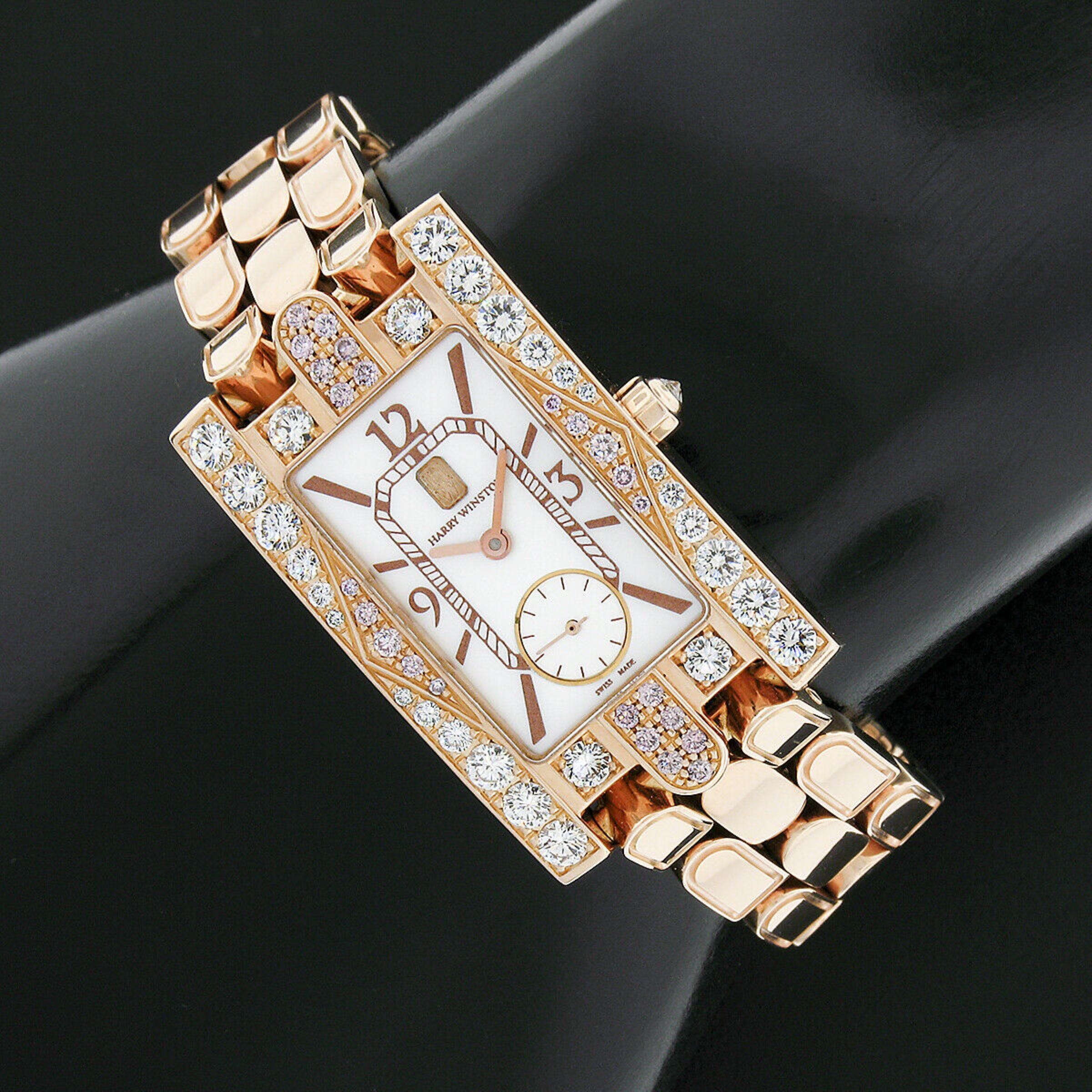 This fancy and super elegant ladies' wrist watch by Harry Winston is completely crafted from solid 18k rose gold. The 21mm rectangular shaped case is adorned with the round brilliant IDEAL cut white and fancy pink diamonds, very neatly pavé set