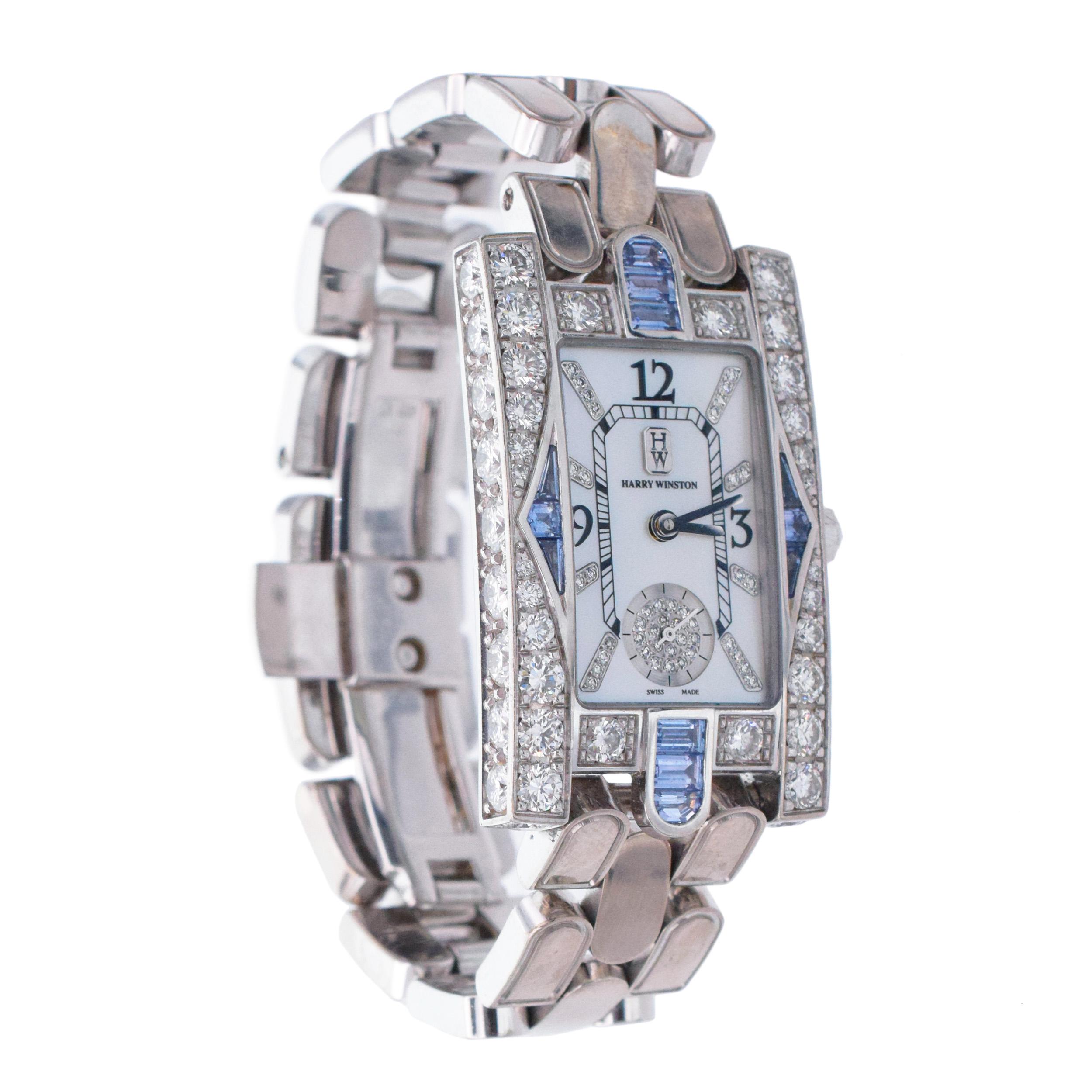 Harry Winston' Avenue ' Classic Aurora Mother-of-
Pearl, Diamond And Sapphire Wrist Watch In 18k White Gold.
Crafted in 18k white gold. Quartz movement. The watch
features rectangular mother-of-pearl dial,  black Arabic numerals at 12:00, 3:00 and