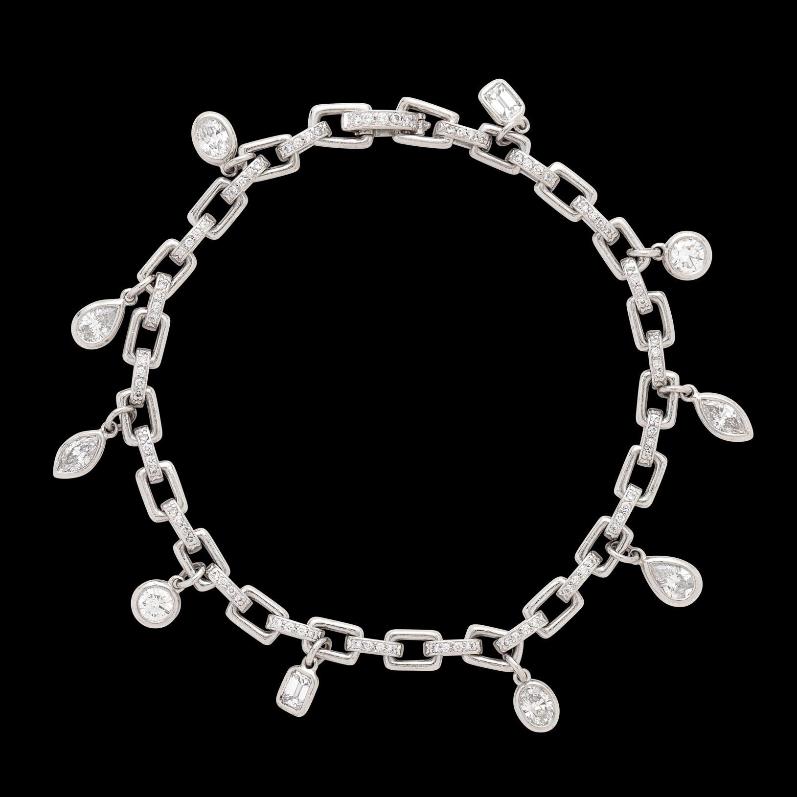 A wonderful spin on the charm bracelet, by renowned jewelry Harry Winston! This custom one-of-a-kind platinum link bracelet is set with 80 round brilliant-cut diamonds, and suspends 10 bezel-set diamond charms, of assorted shapes. The total diamond