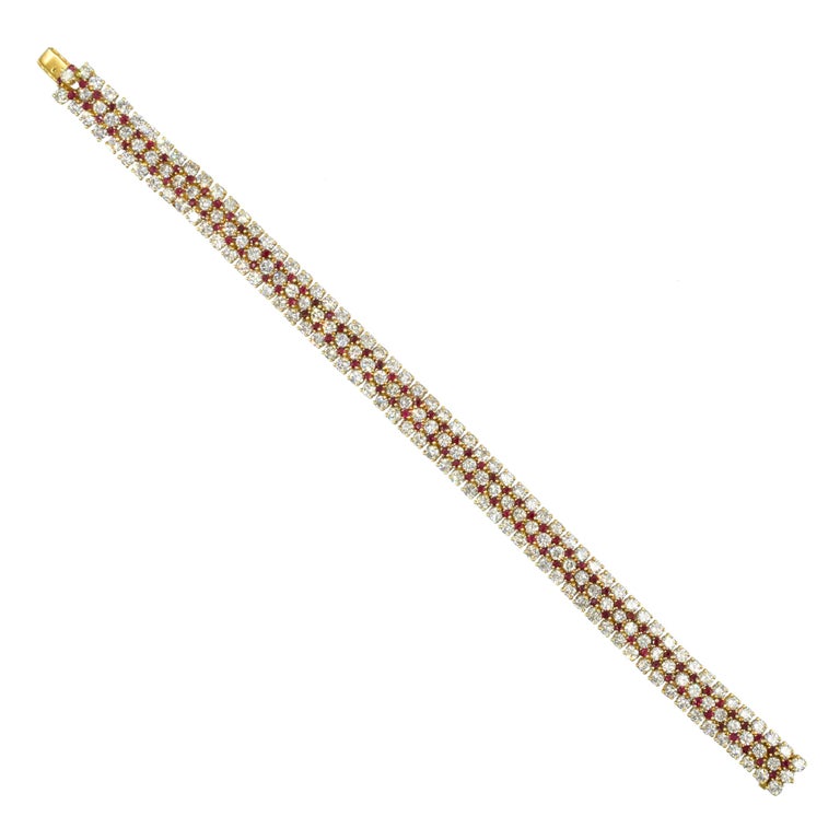 Harry Winston diamond and ruby bracelet in 18k yellow gold. This five row bracelet alternates three rows of diamonds and two rows of rubies. Consisting of 171 round brilliant cut diamonds with total
weight of approximately 11.0ct, color F-G ,