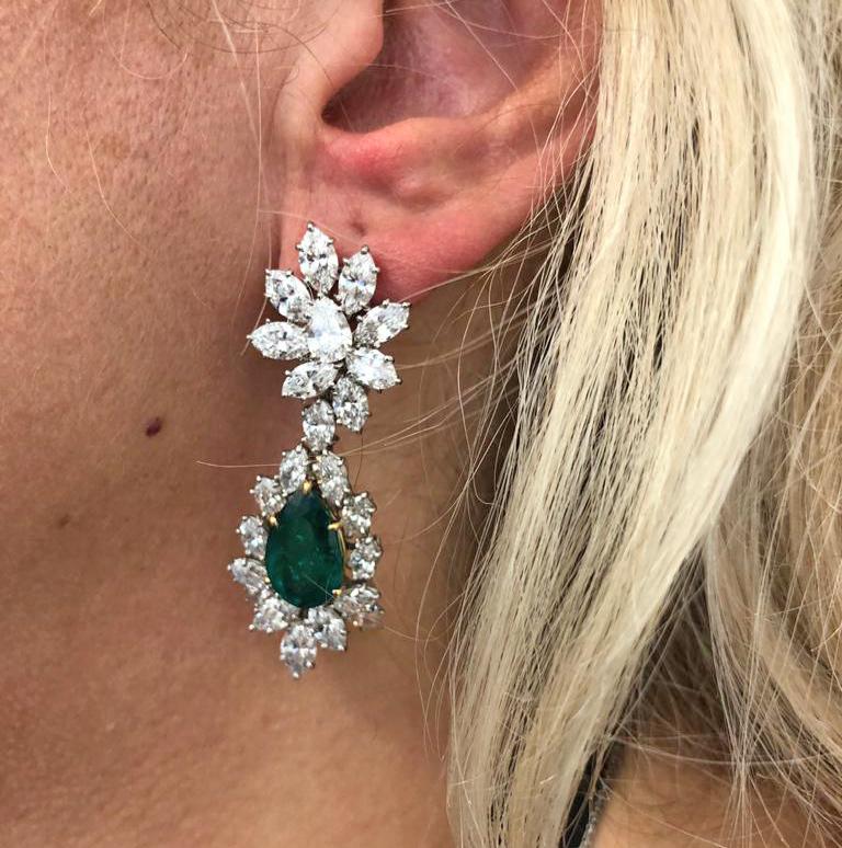 An exquisite pair of diamond and emerald ear pendants by Harry Winston, each set with Colombian pair shaped emerald weighing over 8 carats within a pear shaped diamond cluster frame and a pear shaped diamond cluster surmount weighing approximately