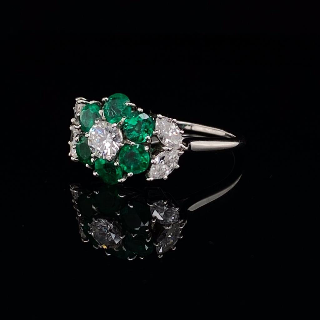 Harry Winston Emerald and Diamond Floral Cluster Platinum Engagement Ring Circa 1980

This stylish floral cluster platinum engagement ring from the 'King of Diamonds' Harry Winston is formed of a claw set round brilliant cut diamond centre with