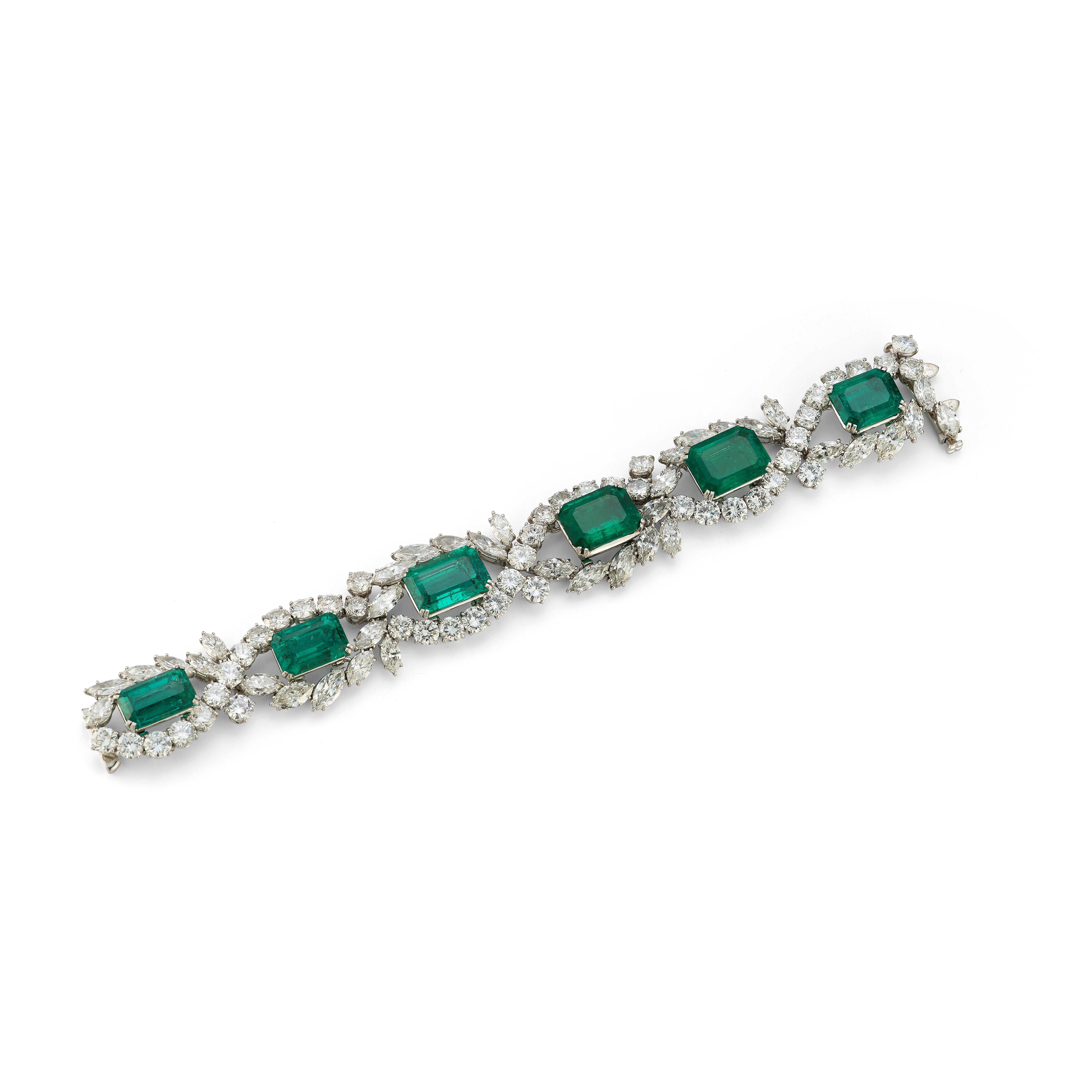 Harry Winston Emerald & Diamond Bracelet. 

Set with a row of six emerald-cut emeralds weighing 39.39 carats, to the open-work frame of diamond clusters with round brilliant-cut diamonds and marquise-shaped diamonds, mounted in