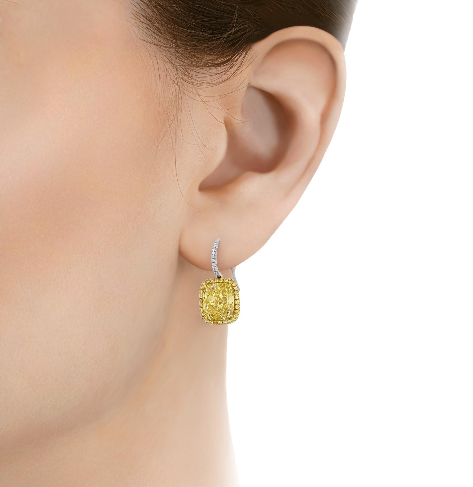 These extraordinary earrings by Harry Winston showcase a perfectly matched pair of cushion modified brilliant cut fancy intense yellow diamonds. Weighing 5.07 and 5.08 carats respectively, these gemstones are graded by the Gemological Institute of