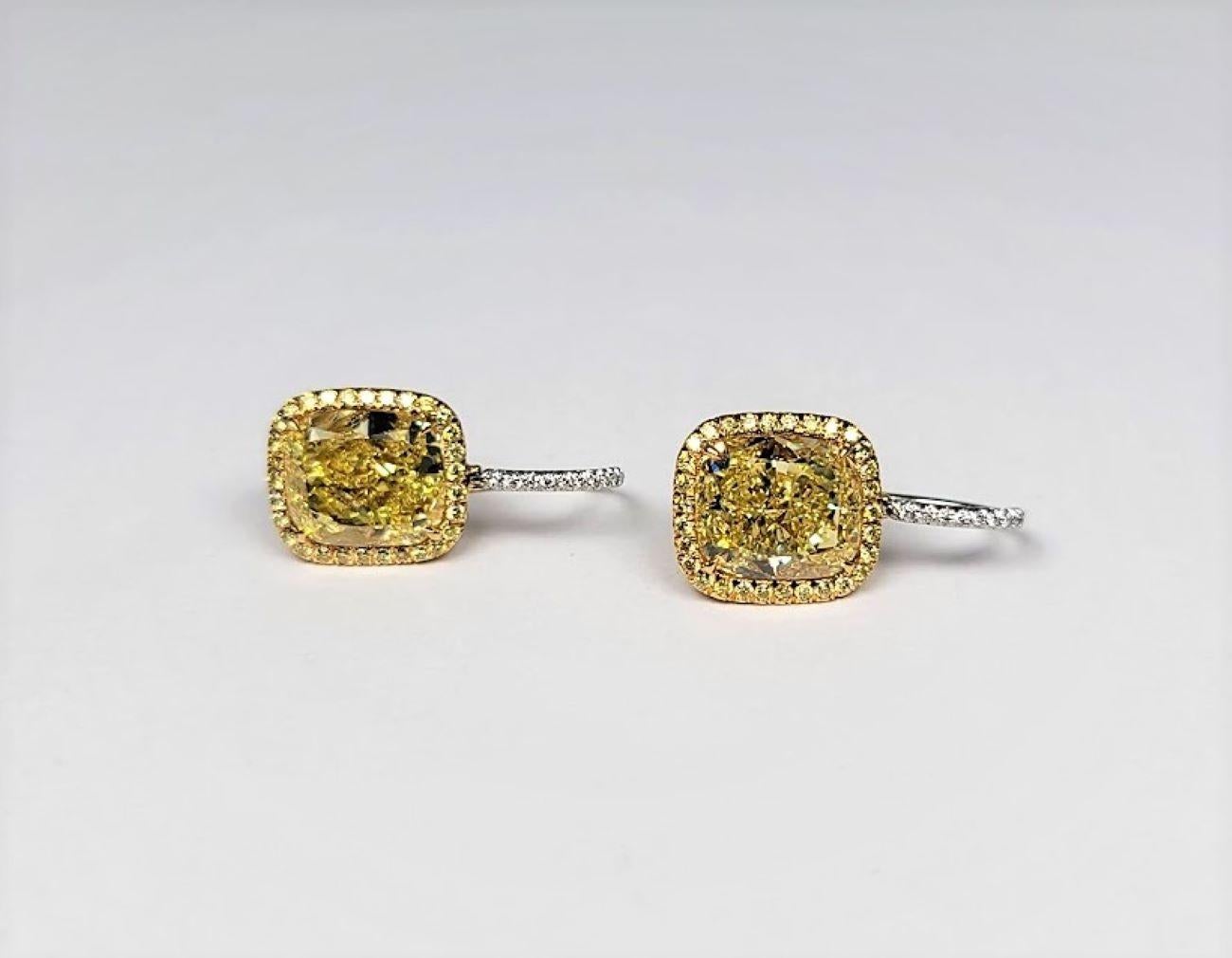 Set with a pair of cushion modified brilliant-cut natural color, fancy intense yellow diamonds, weighing 5.07 cts, VS 2, Fancy Intense Yellow (GIA),  and 5.08 cts, VVS 2, Fancy Intense Yellow (GIA) each within a frame of 113 pave-set, fancy yellow