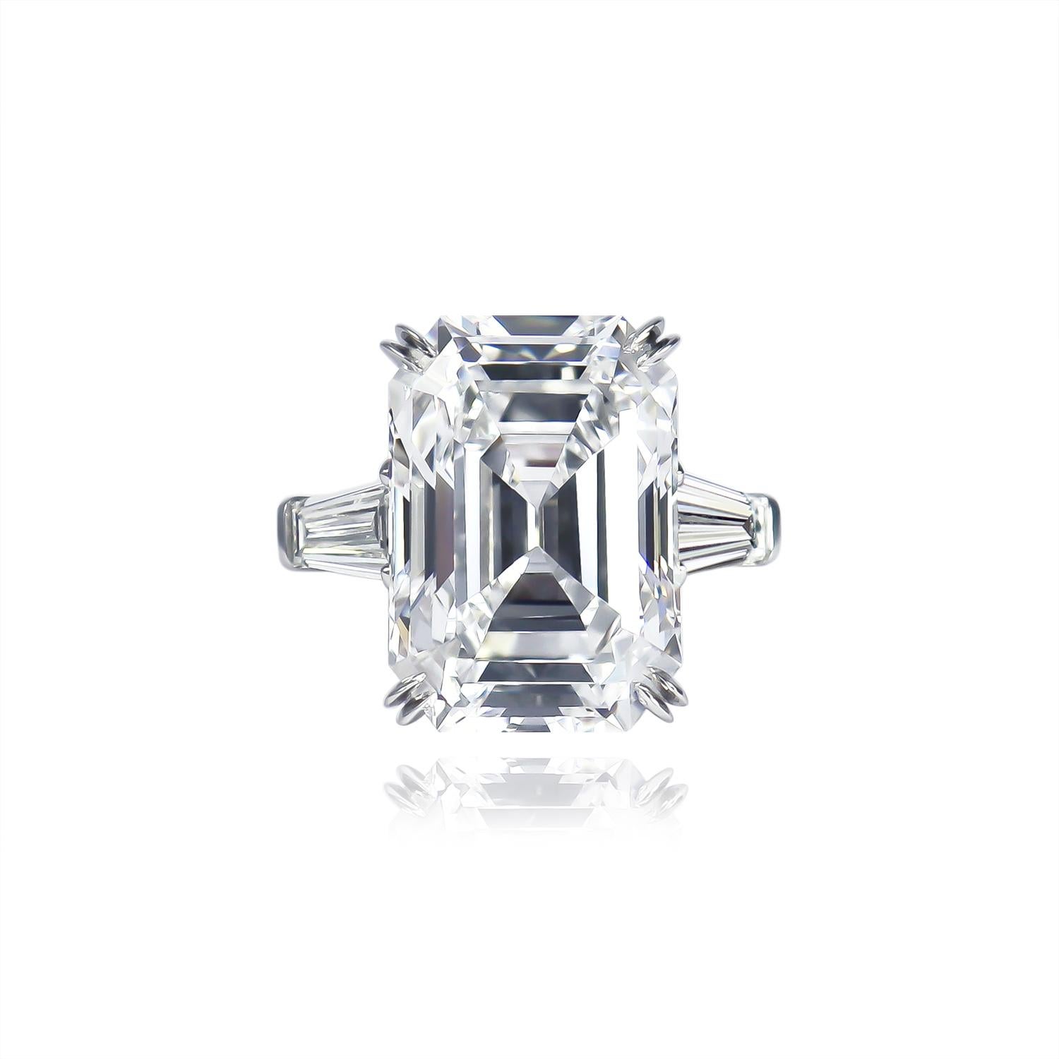 This exquisite ring from the house of Harry Winston features a 12.14 carat Emerald cut diamond of D color and Internally Flawless clarity as described by GIA grading report #5211073255. Set in a signed, platinum ring with tapered baguette side