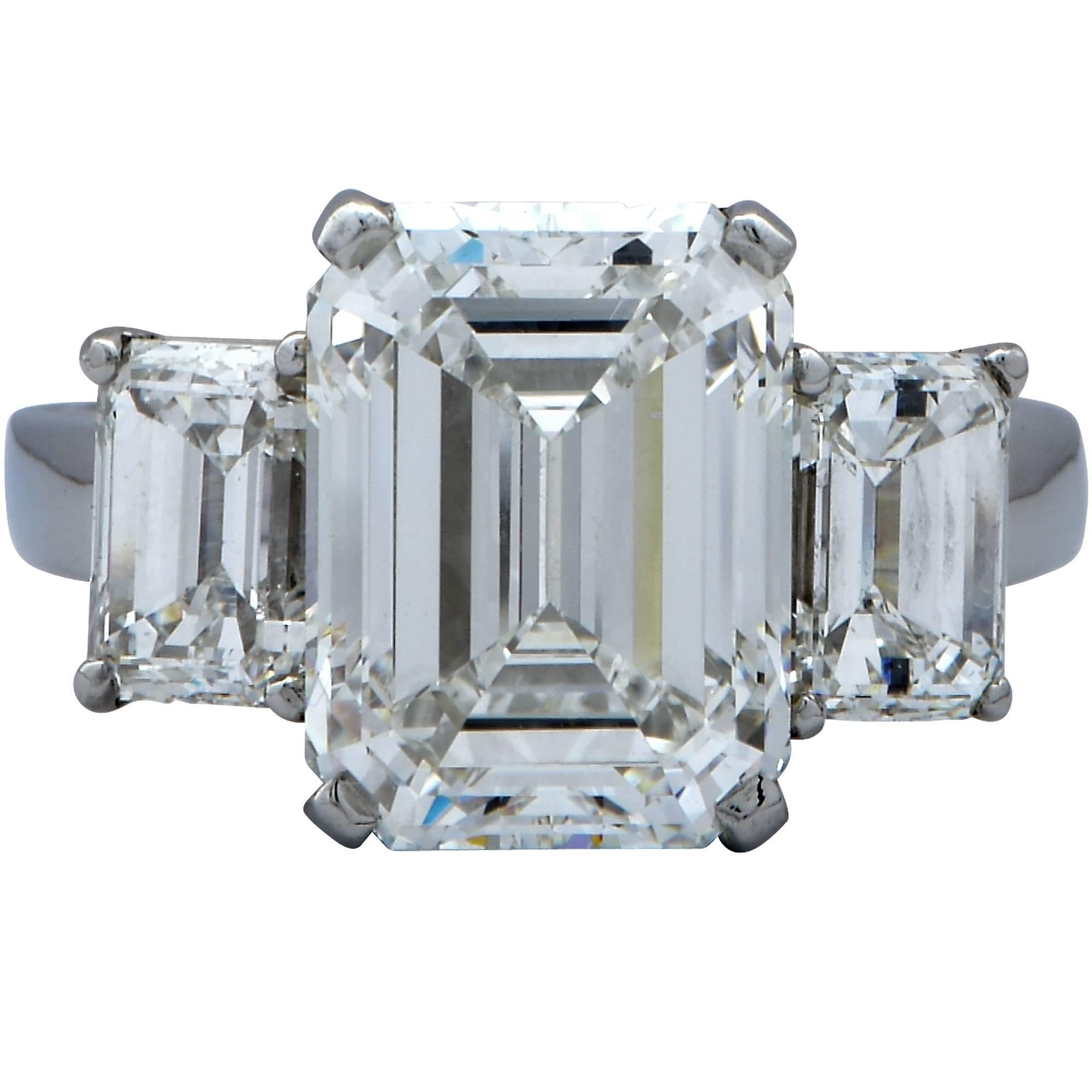 Spectacular diamond engagement ring crafted by Harry Winston and hand forged out of fine platinum. Showcasing an elegant GIA graded emerald cut diamond weighing 5.11cts, H color, VS2 clarity, this ring is a showstopper. Flanking the center diamond