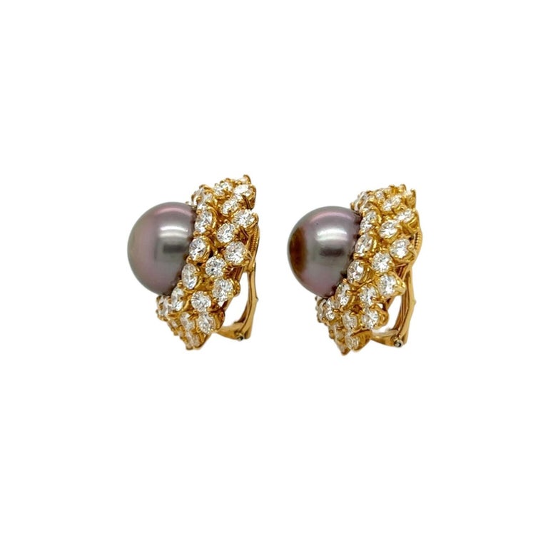 A pair of 18 karat yellow gold, pearl and diamond earclips, Harry Winston.  Each earclip centering a Tahitian pearl measuring approximately 13.4 mm surrounded by three rows of fourteen brilliant cut diamonds each.  Total diamond weight approximately