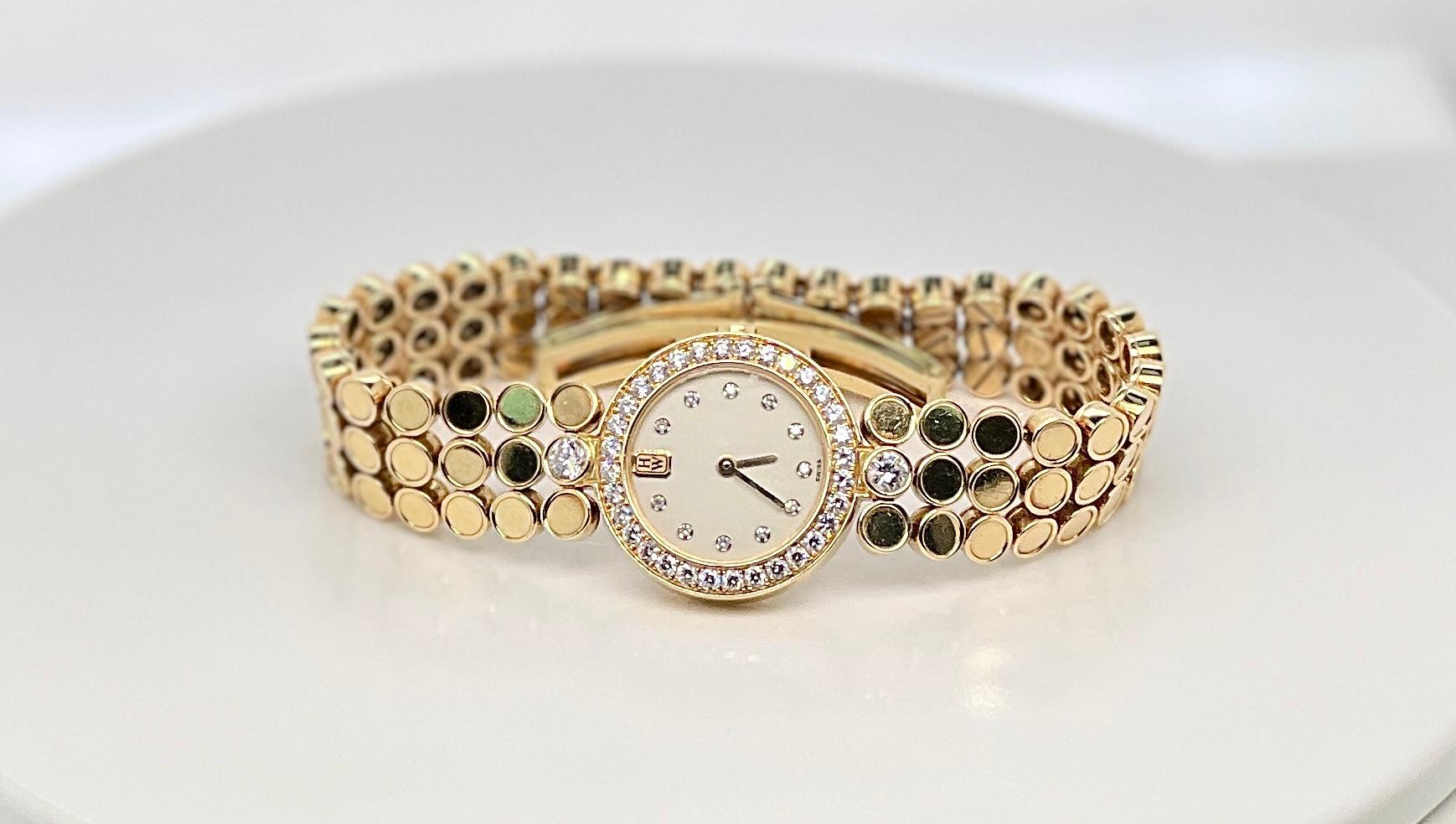 Montre Harry Winston pour dames en or jaune 18 carats avec lunette en diamants

Cette luxueuse montre Harry Winston pour femme en or jaune 18 carats est dotée d'une lunette et d'index sertis de diamants éblouissants. Le boîtier rond caractéristique