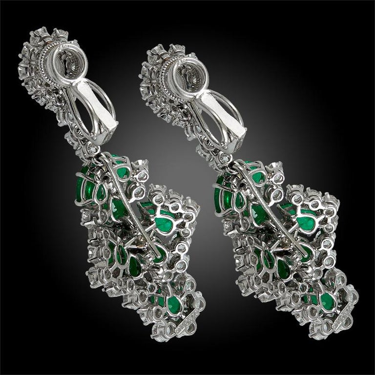 HARRY WINSTON Emerald Diamond Chandelier Earrings in Platinum.

A remarkable pair of chandelier on-the-ear clips by Harry Winston comprised with pear shaped emeralds surrounded by round brilliant cut diamonds, suspending from a pear-shaped diamond
