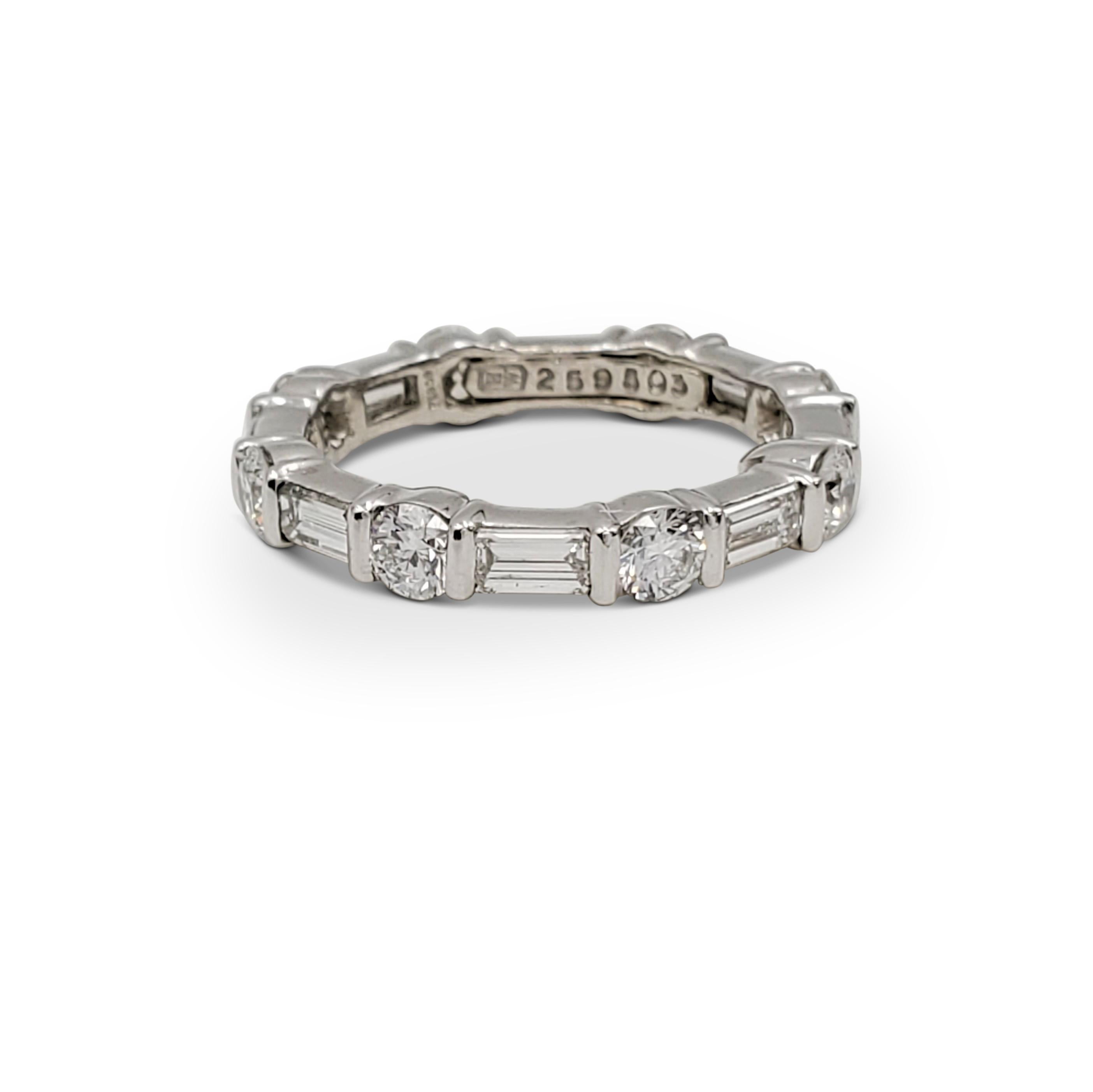 Authentic Harry Winston eternity band crafted in platinum and bar-set with alternating round brilliant and emerald-cut diamonds (E-F, VS) weighing an estimated 1.65 carats total weight. Signed HW, PT950, with serial number. Ring size 3 1/4. The ring