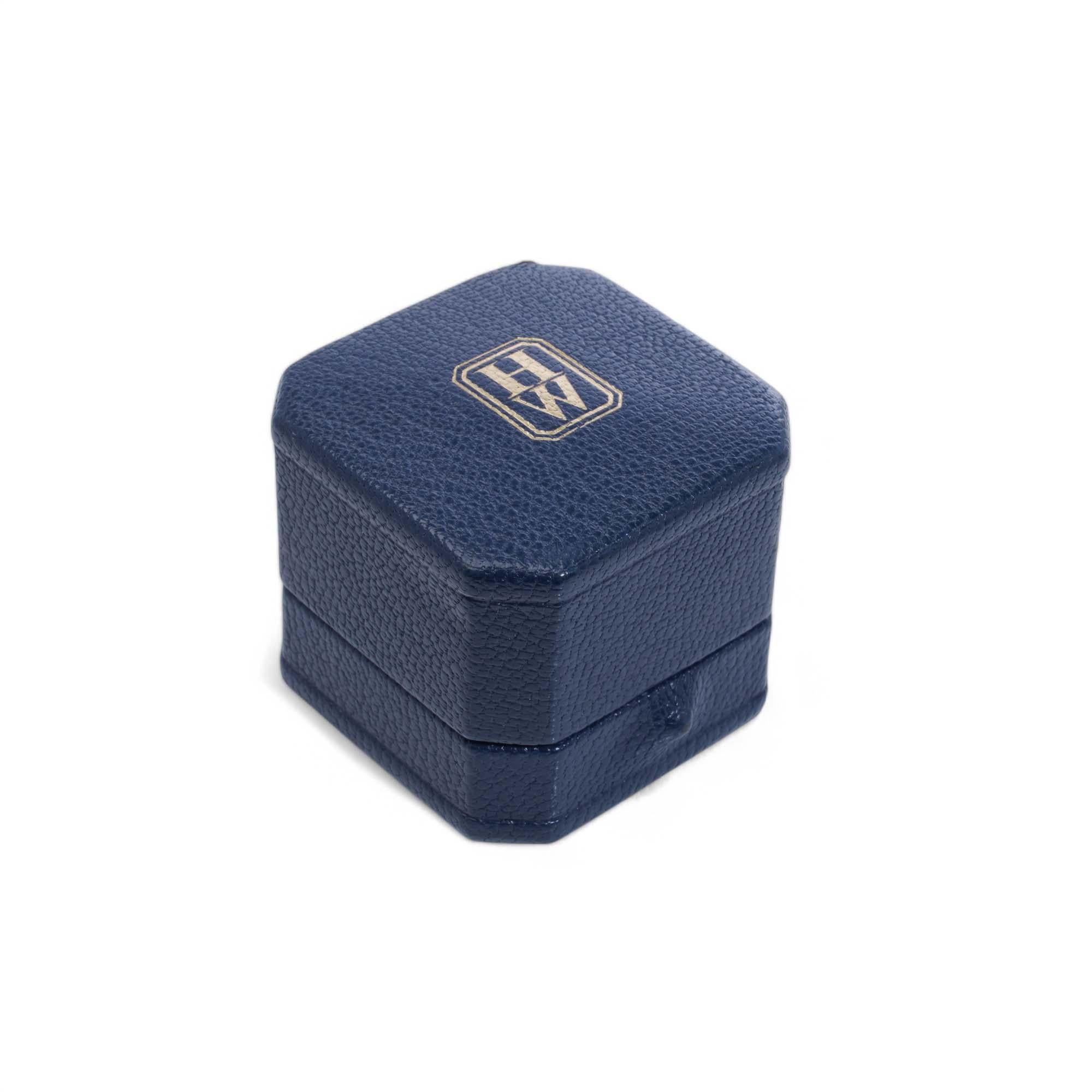 Boîte à bagues Harry Winston. 

Période : Fin du 20e siècle
MATERIAL : Extérieur en cuir bleu et intérieur doublé de satin et de velours blanc
Objet : Conçu pour la présentation et le stockage des bagues
Dimensions : 5 x 4,5 x 5 cm : 5 x 4,5 x 5