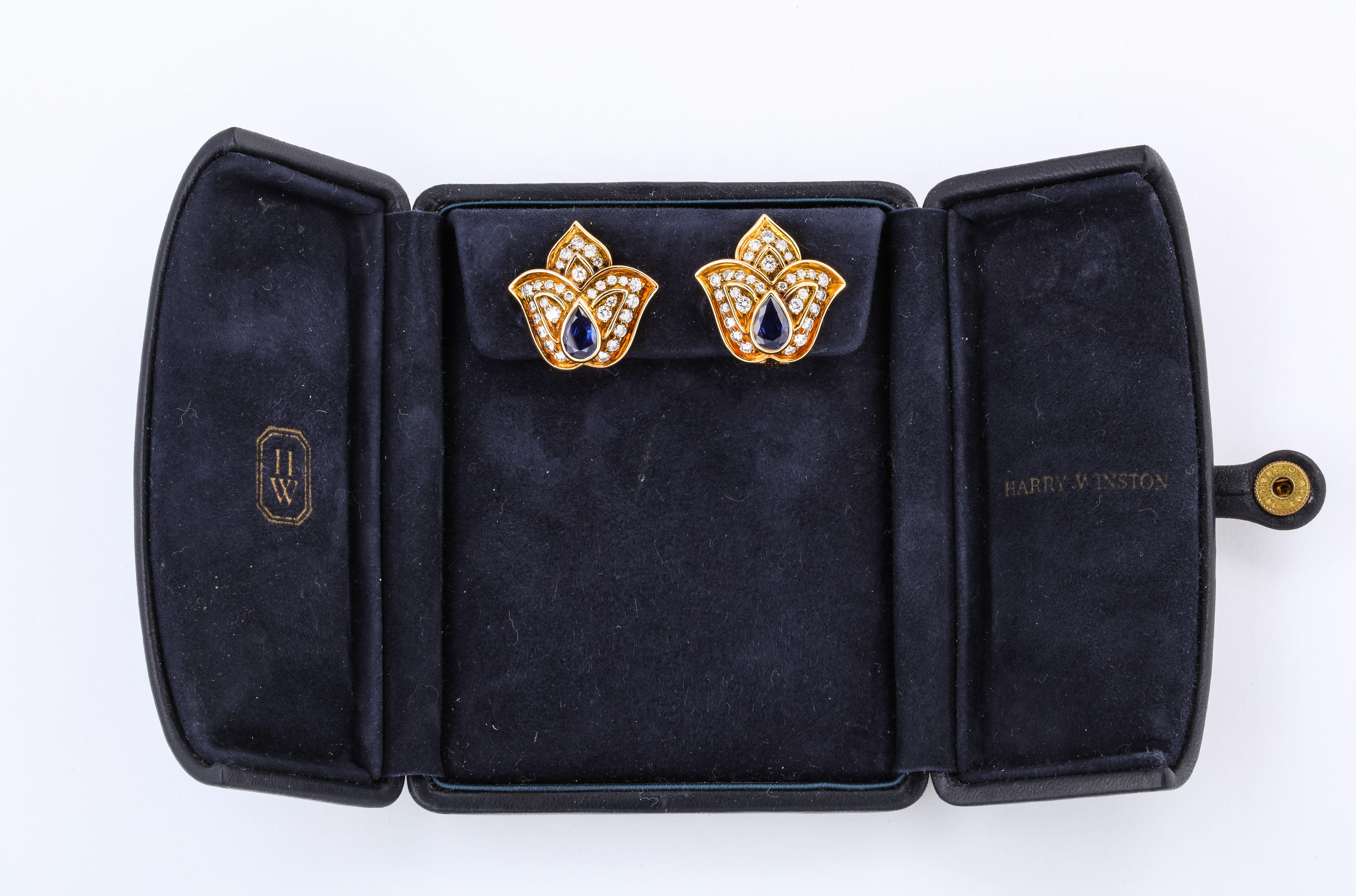 This lovely pair of Harry Winston Sapphire Diamond Yellow Gold Tulip Clip Earrings is offered here in their original case. They are composed of 2 pear shaped sapphires and Fine White Full Cut Diamonds, and are set in 18k Yellow Gold.

Materials:
18k