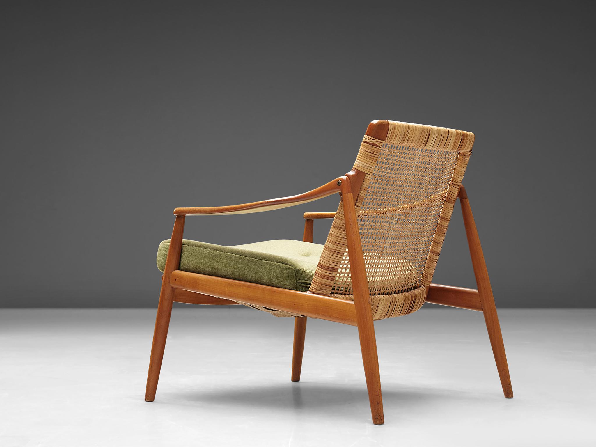 Hartmut Lohmeyer for Wilkhahn, 2 armchairs, green fabric, teak and rattan, Germany, 1956.

This lounge low armchair is sensuous and organically shaped. It features a slightly tilted back and is detailed with tapered legs. The softly bent armrests