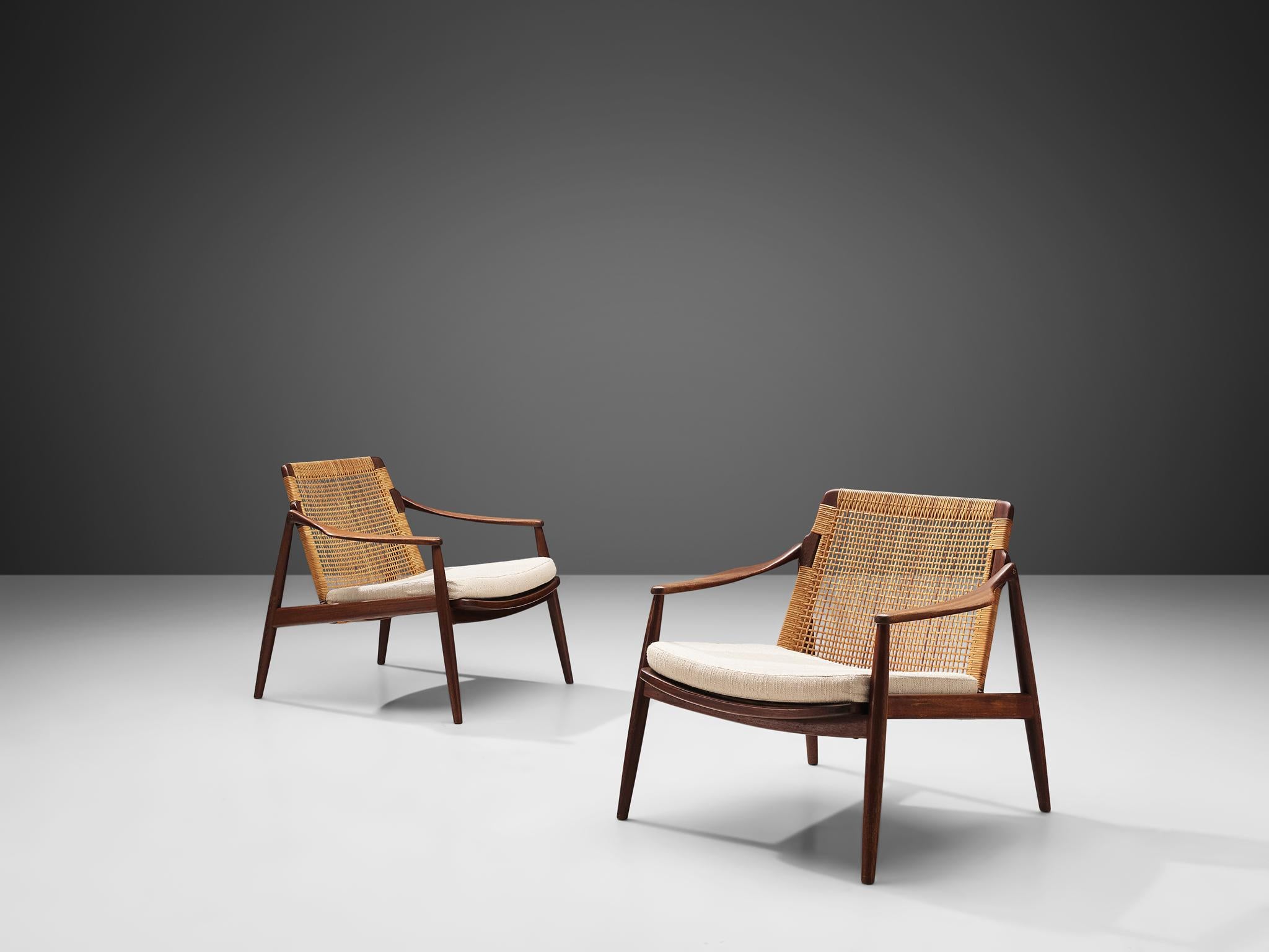 Hartmut Lohmeyer for Wilkhahn, armchairs, teak, cane, cream colored upholstery, Germany, 1960s.

This low reclining armchair is sensuous and is organically shaped. They feature a slightly tilted back and are executed with tapered legs. The softly