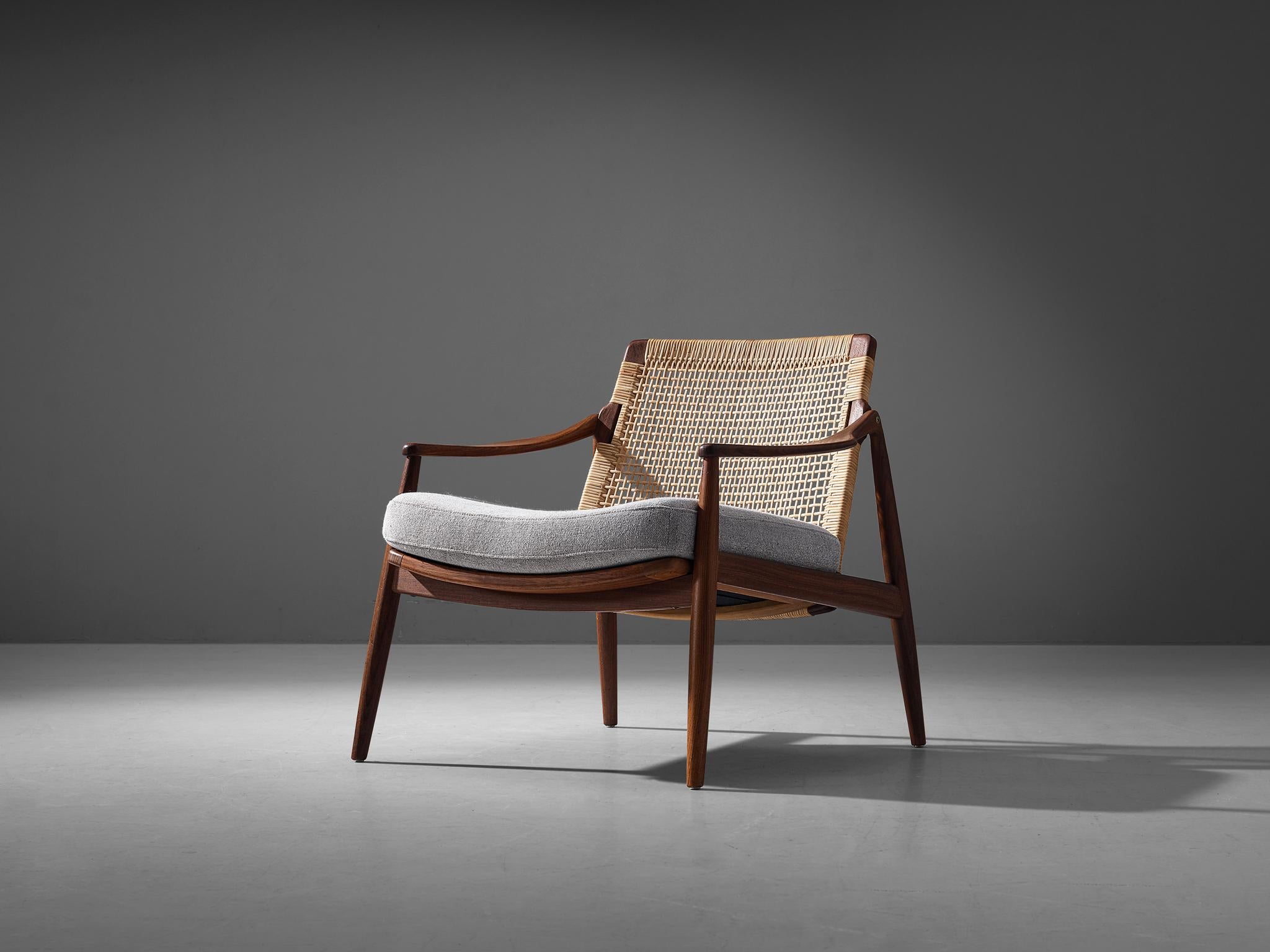 Hartmut Lohmeyer for Wilkhahn, lounge chair, teak, cane, fabric striped upholstery, Germany, 1960.

The lounge chair by Hartmut Lohmeyer is organically shaped. The wide open teak frame features a slightly tilted back made out of cane. The softly