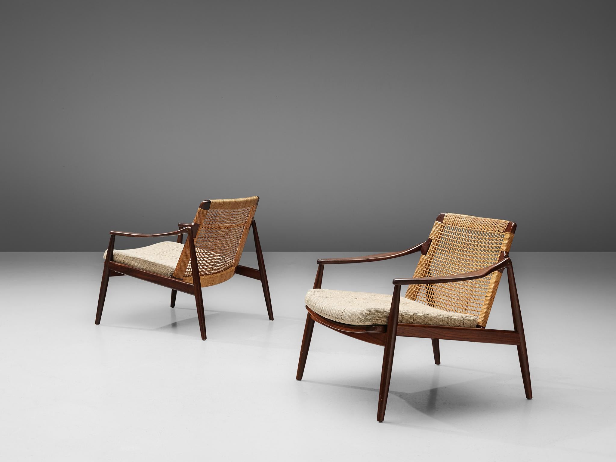 Hartmut Lohmeyer for Wilkhahn, pair of lounge chairs, teak, cane, cream colored upholstery, Germany, 1960s.

This low reclining lounge chair by Hartmut Lohmeyer is organically shaped. The wide open teak frame features a slightly tilted back made