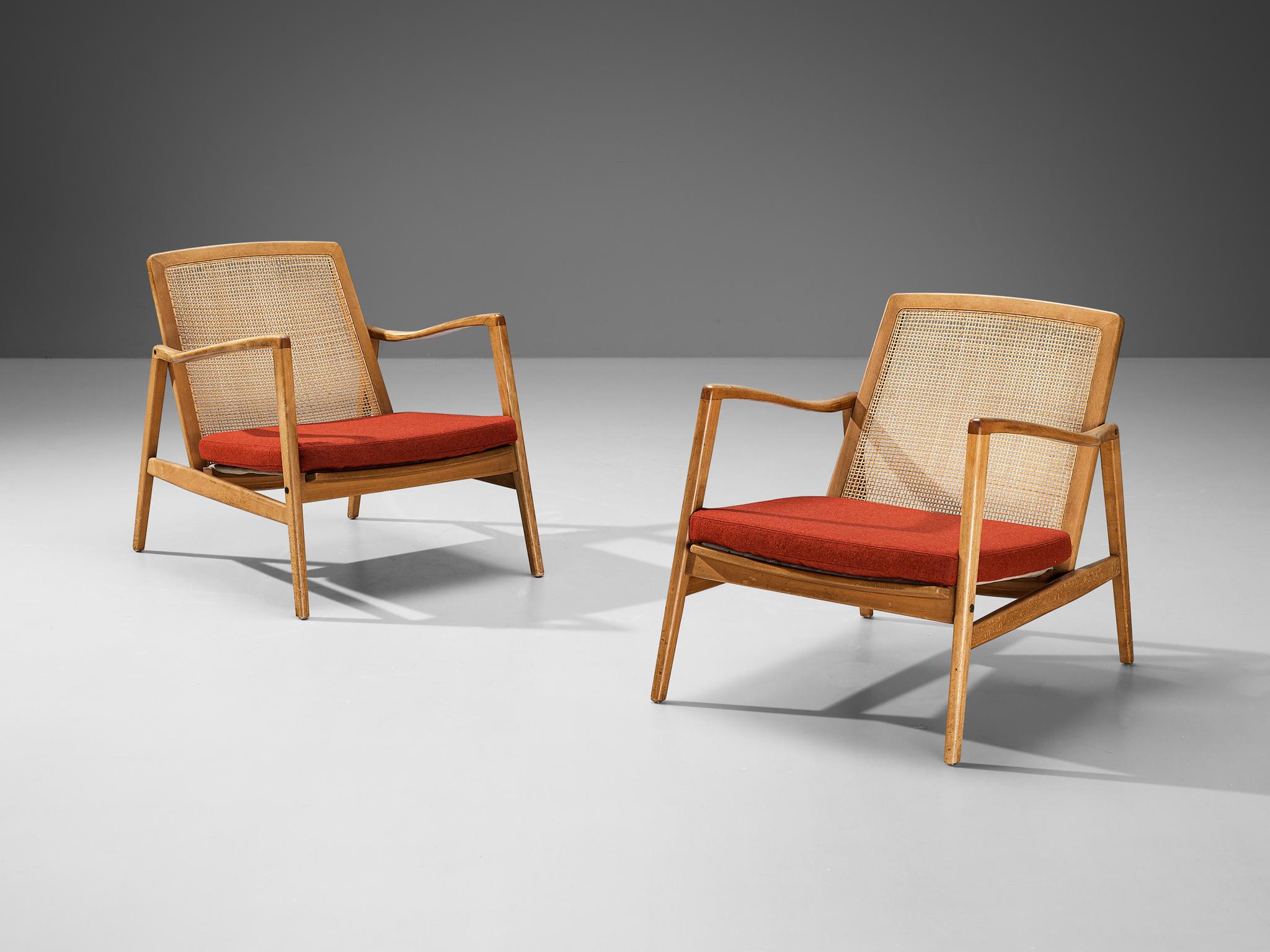 Hartmut Lohmeyer for Wilkhahn, pair of lounge chairs, walnut, beech, cane, fabric, Germany, 1956

These organically shaped lounge chairs by Hartmut Lohmeyer showcase a wide open wooden frame with a gentle tilt in the back, adorned with cane. The
