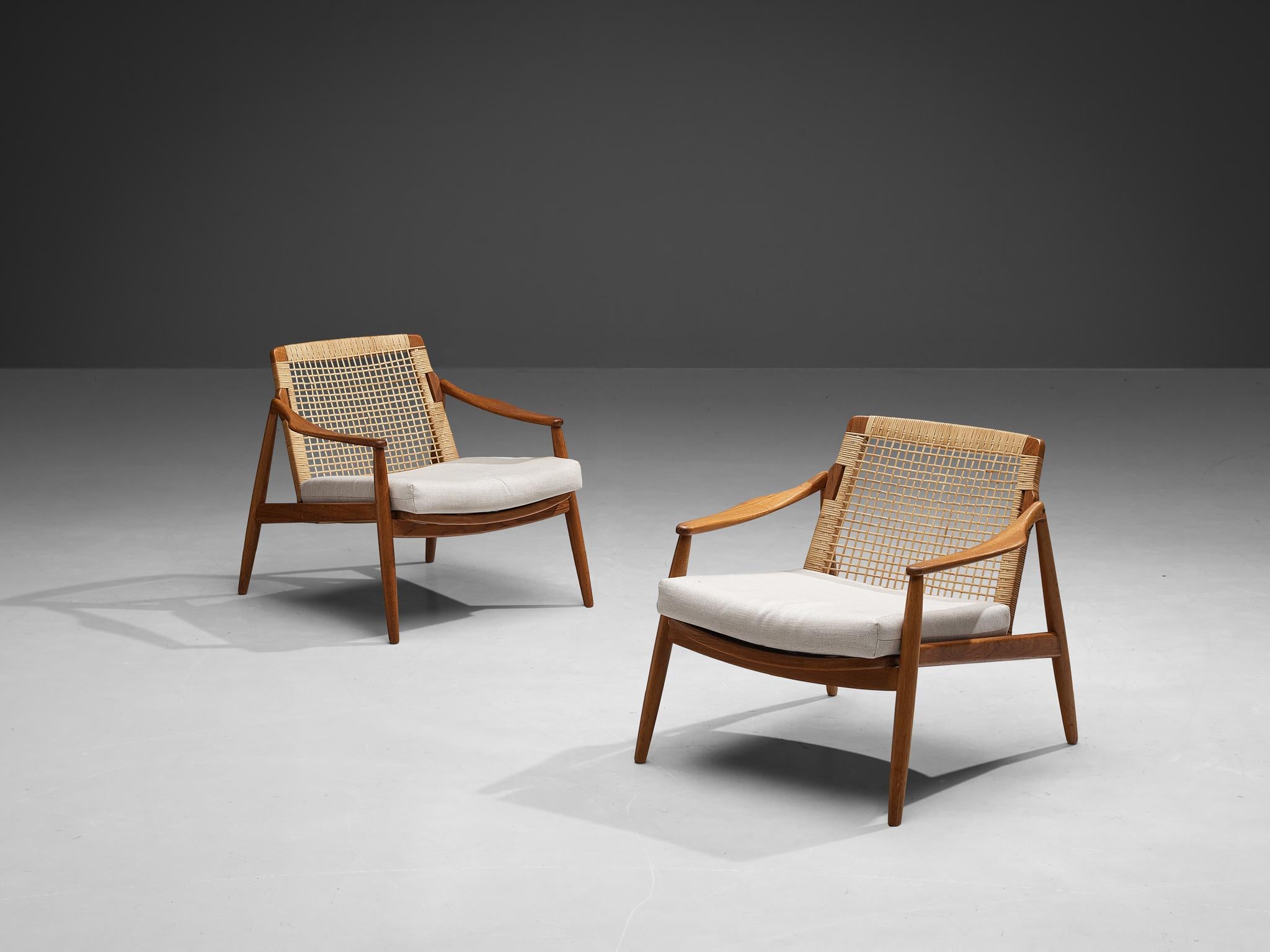Hartmut Lohmeyer for Wilkhahn, armchairs, whitefabric, teak and rattan, Germany, 1956.

This pair of lounge low armchairs is sensuous and organically shaped. It features a slightly tilted back and is detailed with tapered legs. The softly bent
