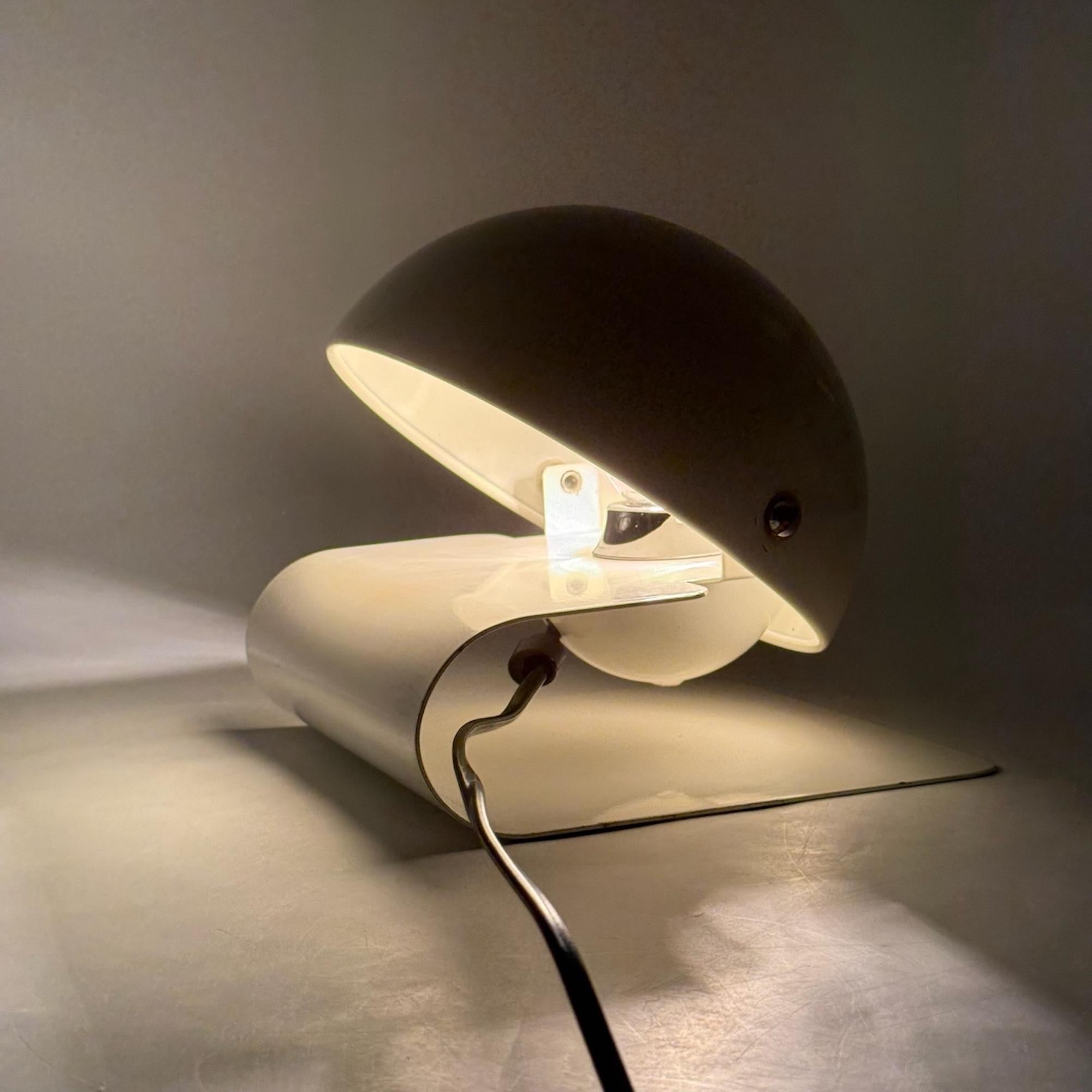Iconic table lamp ‘Bugia’ designed by Giuseppe Cormio for Milano 1975 Fair and produced by Harvey Guzzini in 1976.

Bugia has a sleek, curved base made of a metal sheet with a tiltable half globe lampshade that allows to adjust the light. This piece