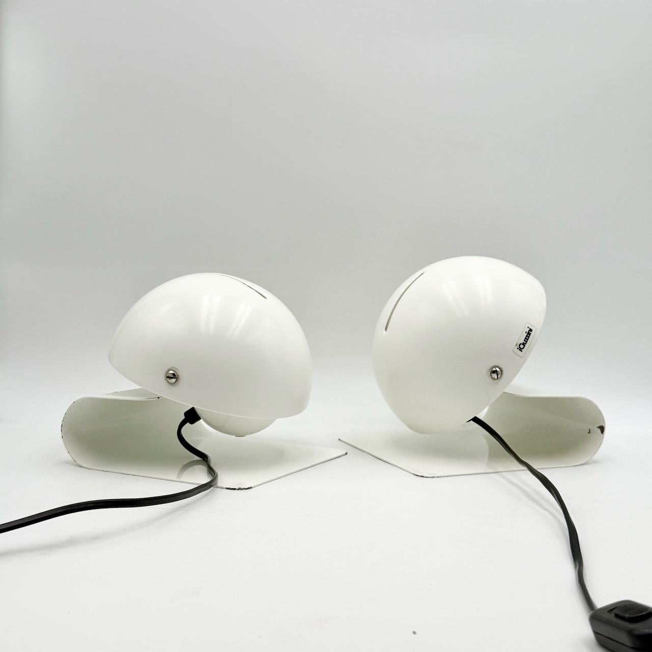 Iconic pair of table lamp ‘Bugia’ designed by Giuseppe Cormio for Milano 1975 Fair and produced by Harvey Guzzini in 1976.

Bugia has a sleek, curved base made of a metal sheet with a tiltable half globe lampshade that allows to adjust the light.