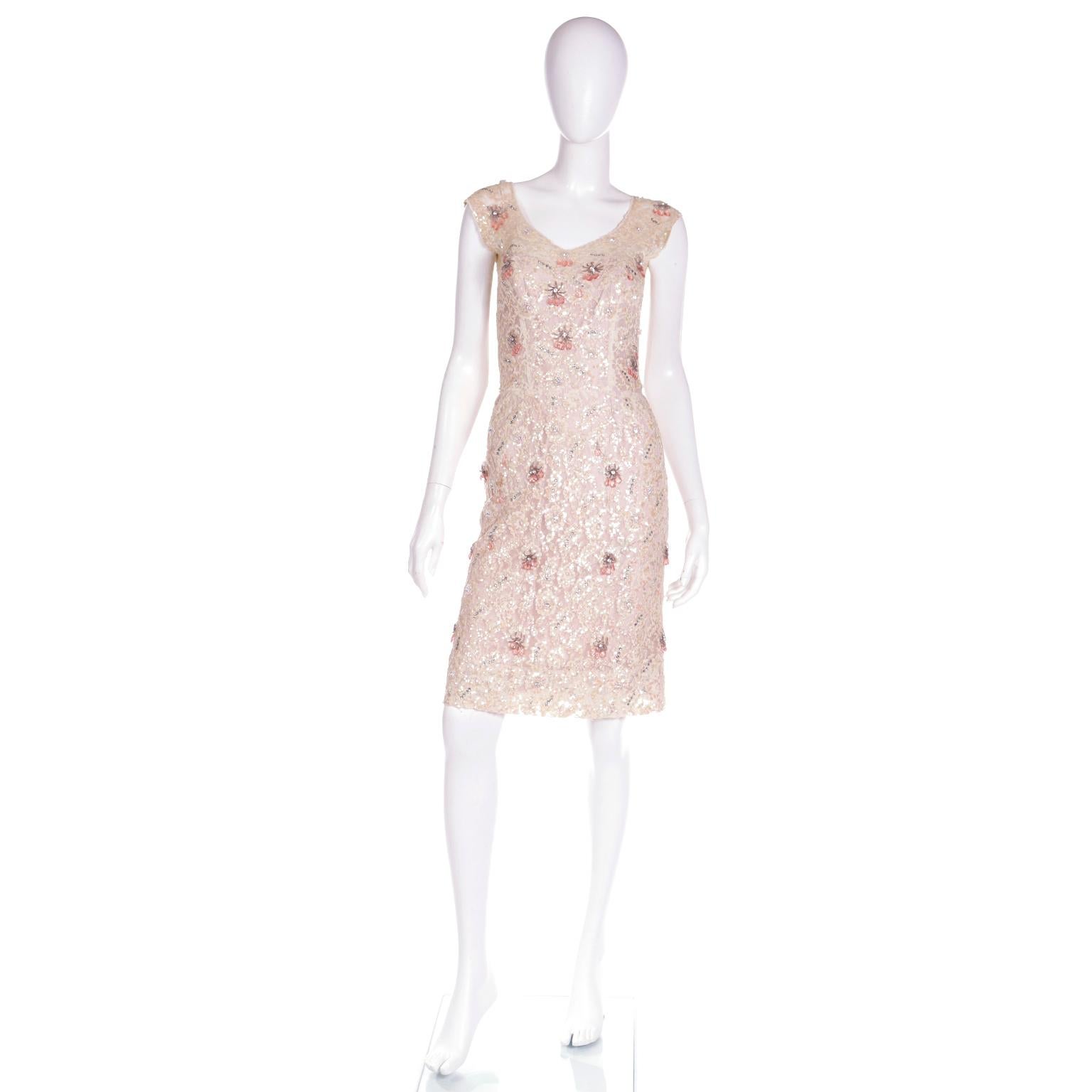 This is a stunning late 1950's Karen Stark for Harvey Berin wiggle dress with a pink satin lining under a lace overlay. The cream lace is embellished with rhinestones and a similar shade of iridescent sequins and the dress has a nice inner corset