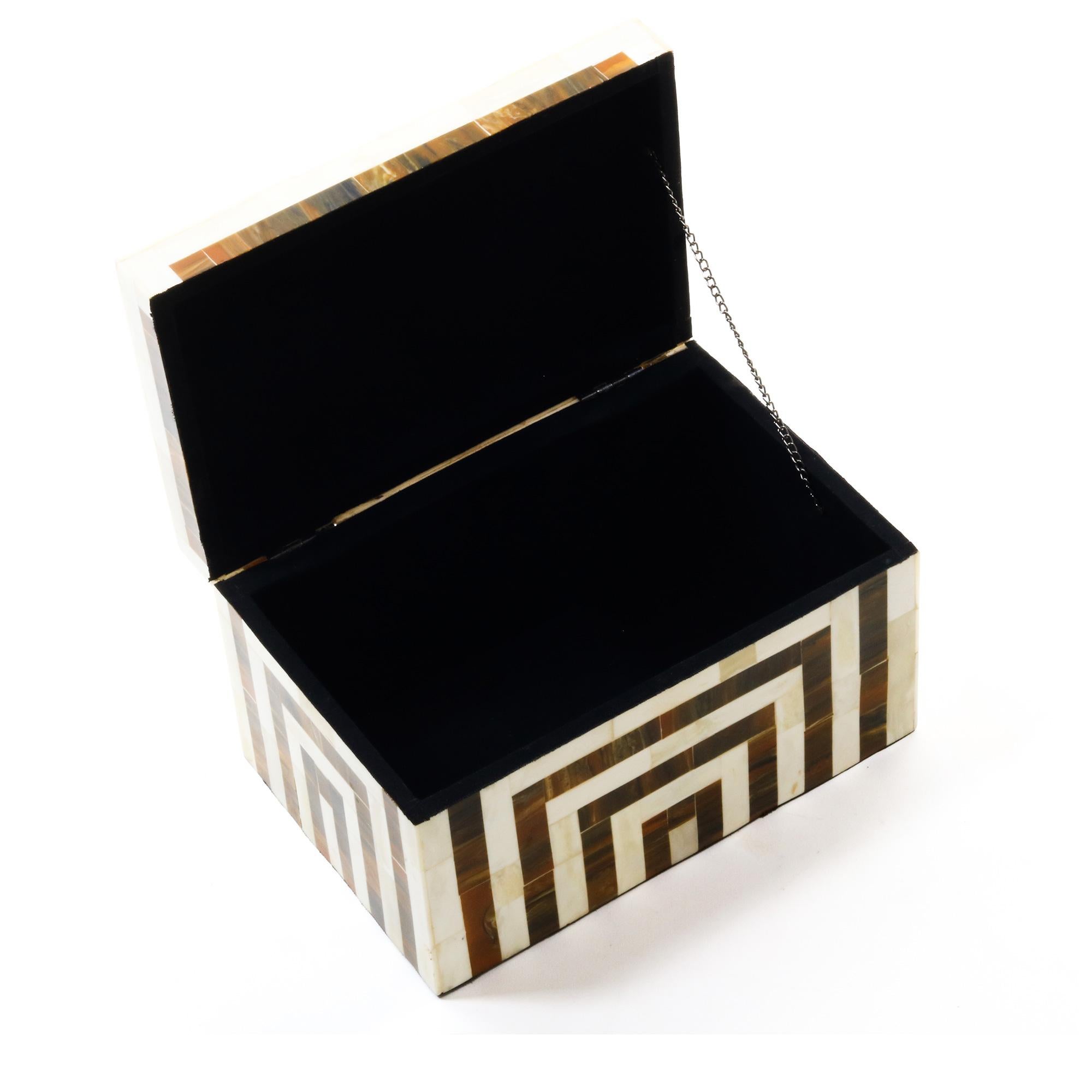An ivory and brown decorative bone and resin box featuring contrasting stripe details.
       
