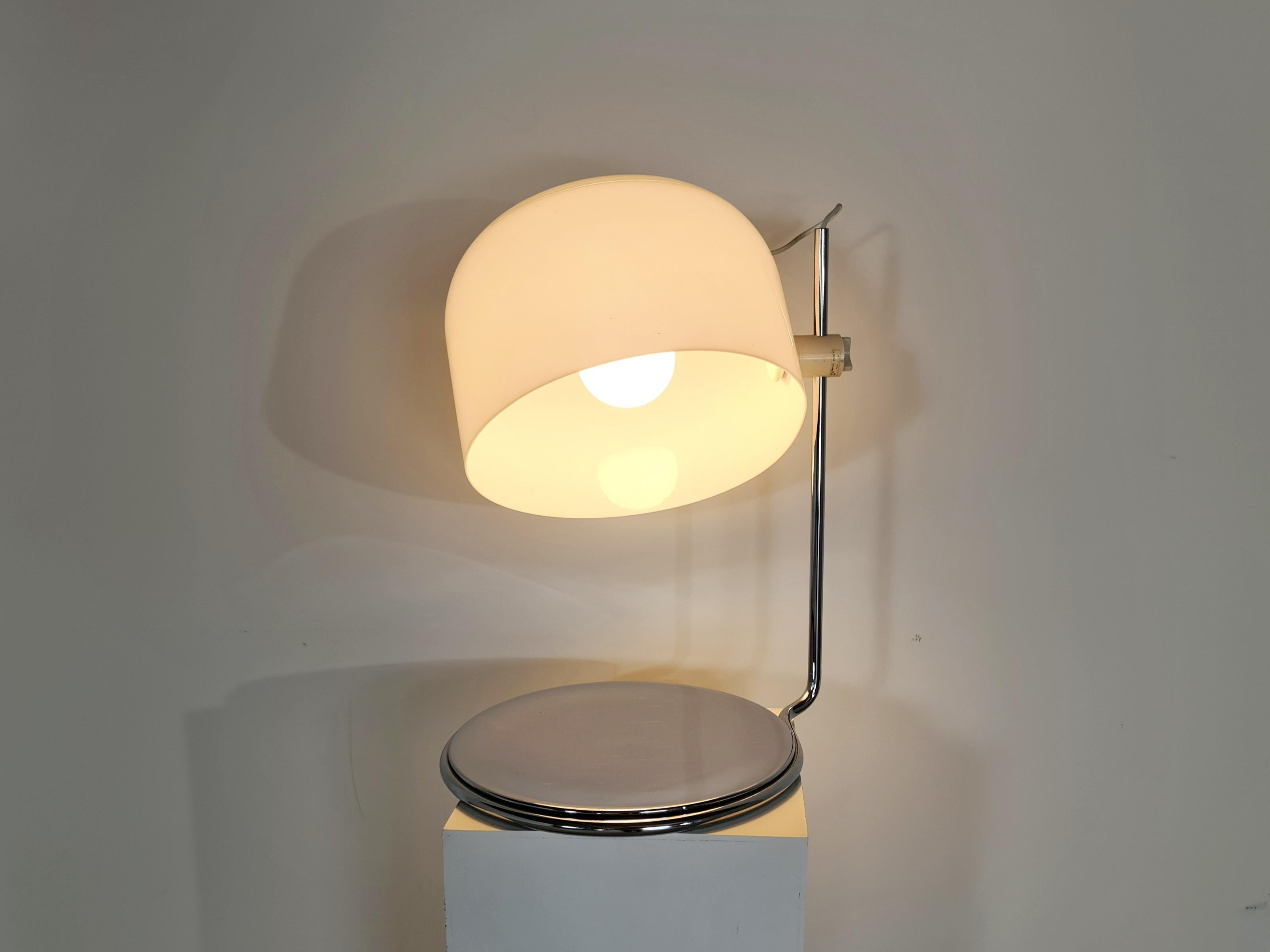 A rare table lamp designed in the 60s by Harvey Guzzini for Guzzini, Italy. Chromed metal foot and frame with white plastic lampshade. The lampshade is very adjustable in position and gives a beautiful light when it is on.

The chrome foot still