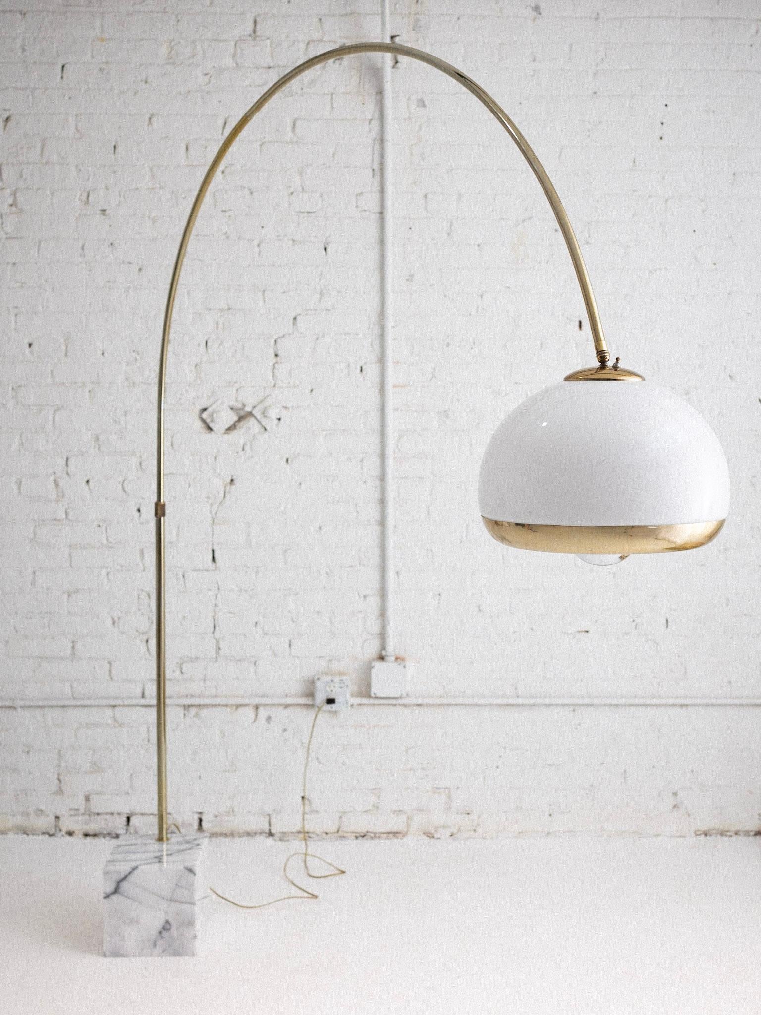 Adjustable gold tone arch lamp with an acrylic globe and white marble base with grey veins. Height can be adjusted from lower tube. Acrylic dome lights from within as well as a lower exposed lightbulb. Shown photographed with a chrome dipped