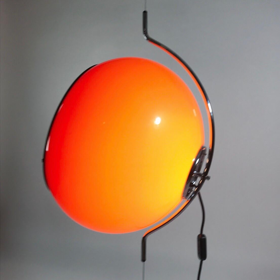 Stunning and awesome are probably the first words which describes this floating light produced by Harvey Guzzini in the early 1970s. 

The iconic Art 4514 with the sideway tilted huge orange shade floating on an almost invisible metal cable. To