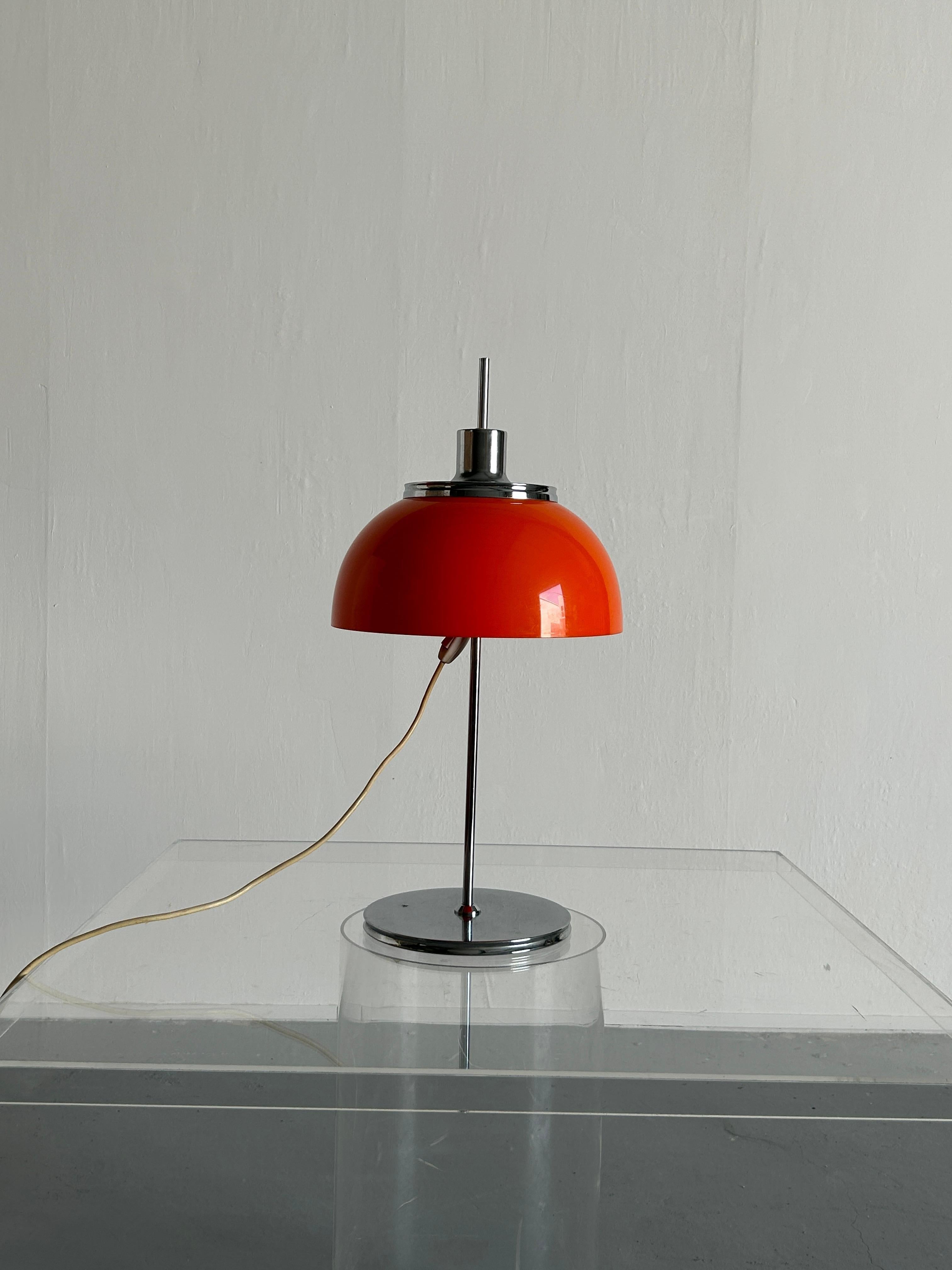 A beautiful orange Mid-Century-Modern table lamp produced by Meblo for Harvey Guzzini Studio throughout the 1960s-1970s. Model 'Faro'. Made from chromed metal and plastic. Can be adjusted to any height with one screw. 

In original vintage
