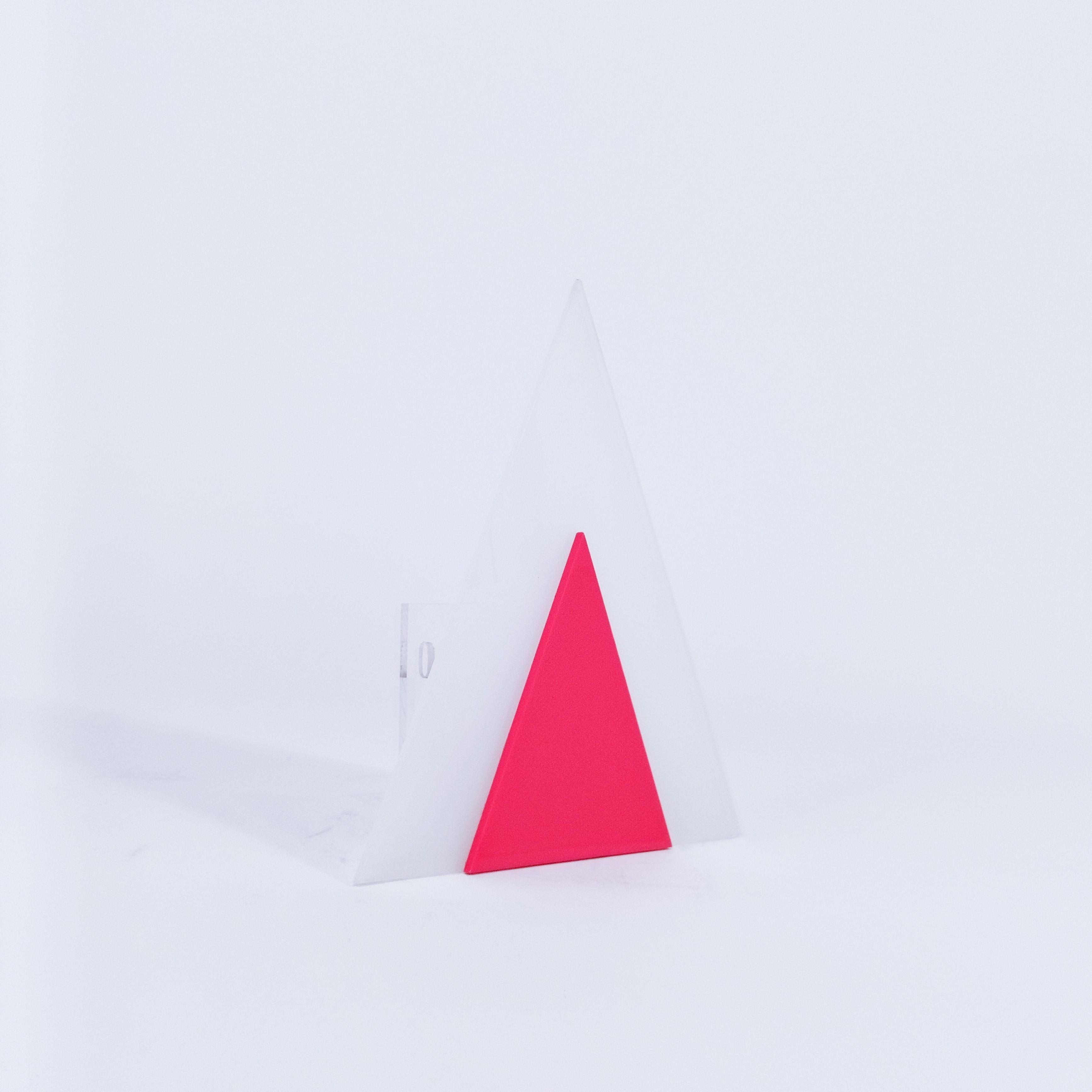 Lampada da parete in stile Memphis e Post-Modern con design geometrico in stile Harvey Guzzini, Italia, anni Settanta. Corpo di forma triangolare formato da due pezzi di acrilico o metacrilato uniti tra loro (uno traslucido e l'altro rosso).