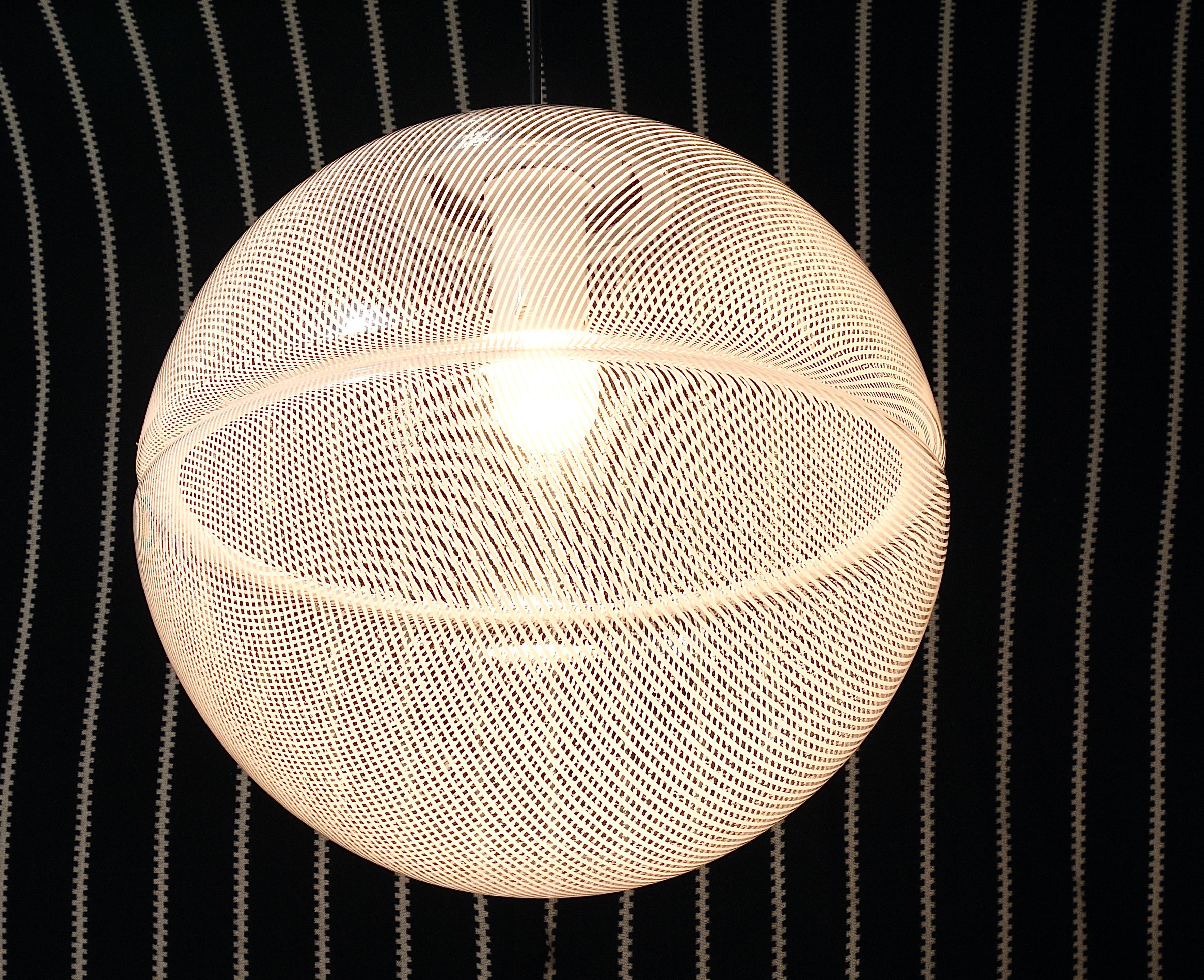 Una grande lampada a sospensione postmoderna Op-Art a strisce degli anni '70, disegnata da Harvey Guzzini per Meblo. La lampada presenta un paralume a globo rotondo molto grande (diametro 15