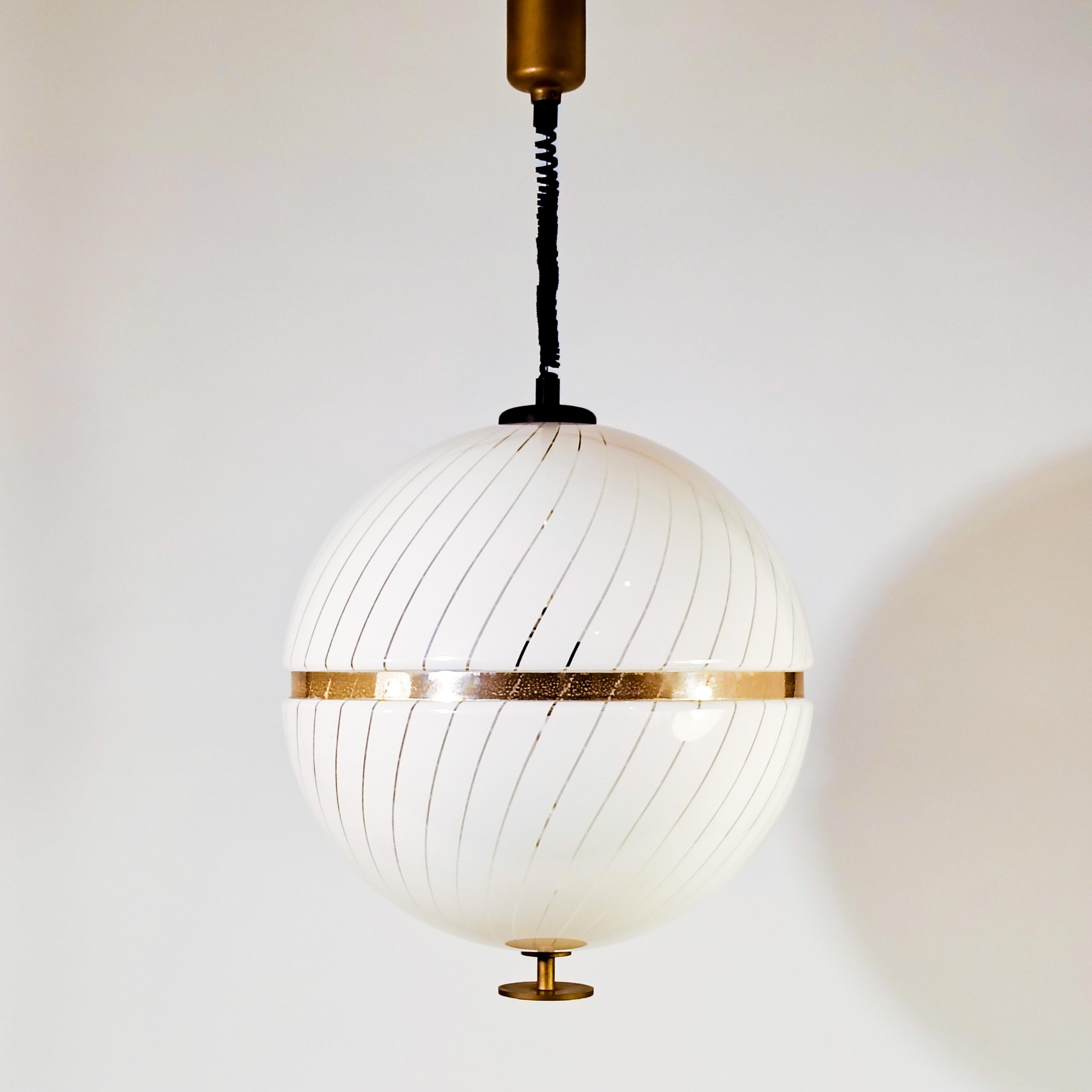 Grande lampada a sospensione in acrilico nello stile delle creazioni di Harvey Guzzini degli anni '80. Forma sferica composta da due semisfere ammortizzate da una struttura interna. All'interno ci sono 3 portalampada. Un design postmoderno e senza