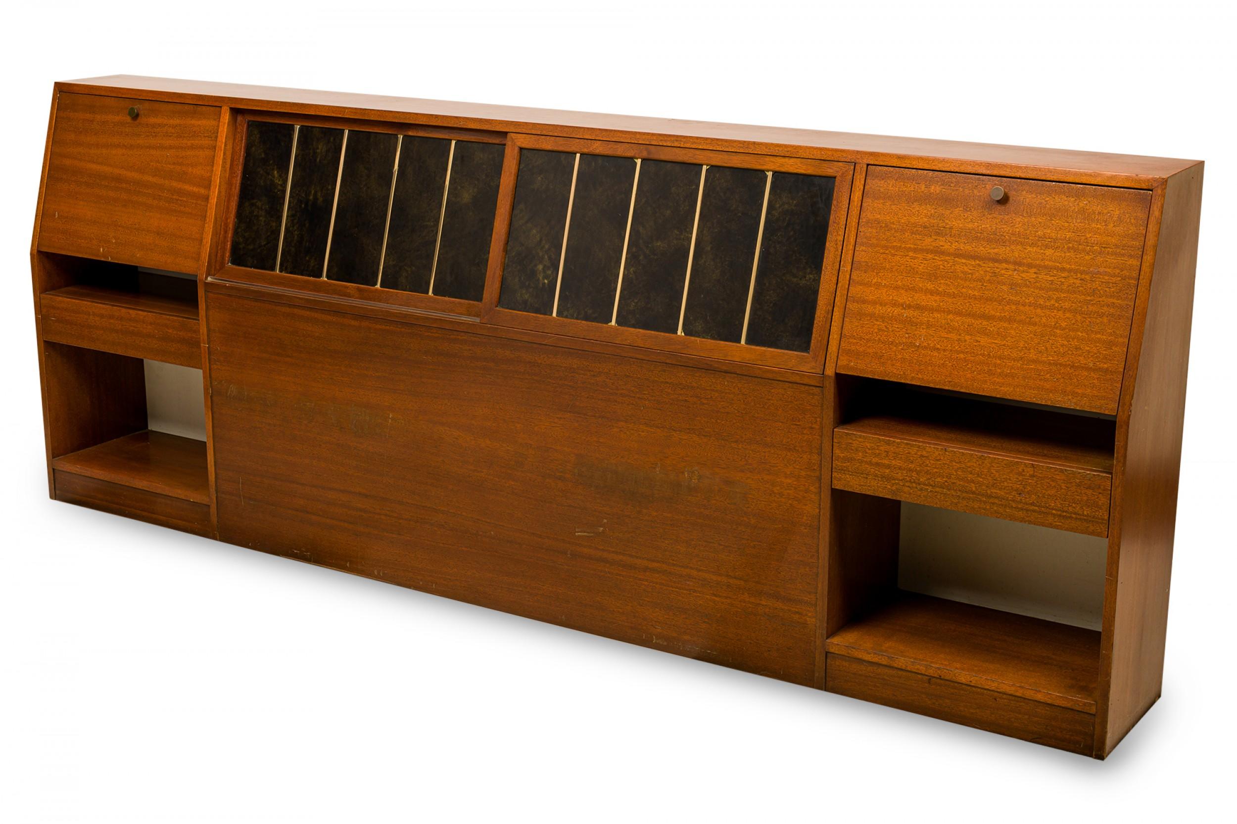American Mid-Century queen-size storage headboard with a wooden veneer cabinet with a slanted front, two exterior Sets of open shelves below two pull down cabinet compartments with lighting and a pivoting compartment, and a central sliding black