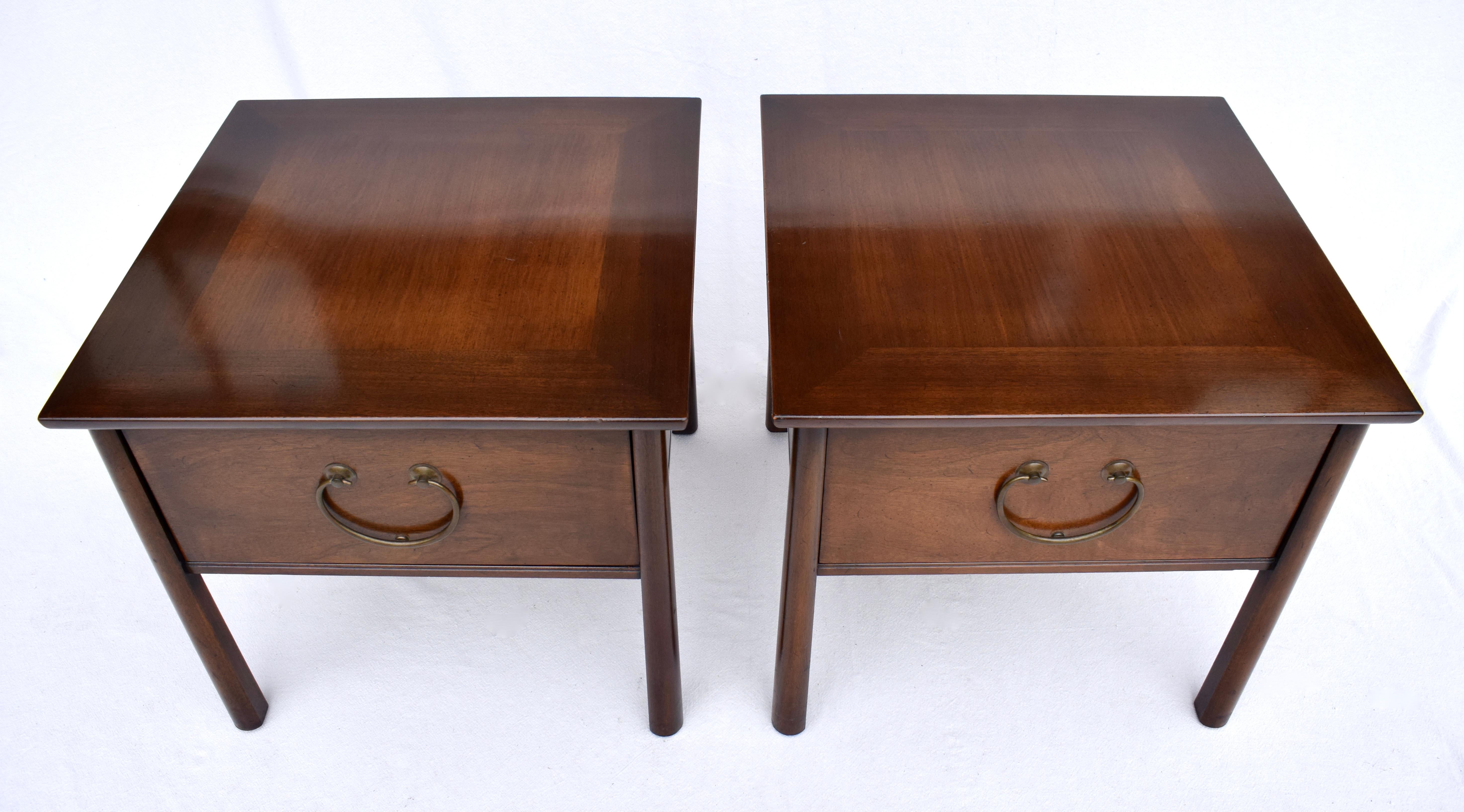 Scarcely seen Henredon Fine Furniture single drawer side end tables or nightstands in Mahogany wood USA circa 1950s. Features include oversized decorative brass pull handles with spacious single drawers & reverse tapered legs bearing the Henredon