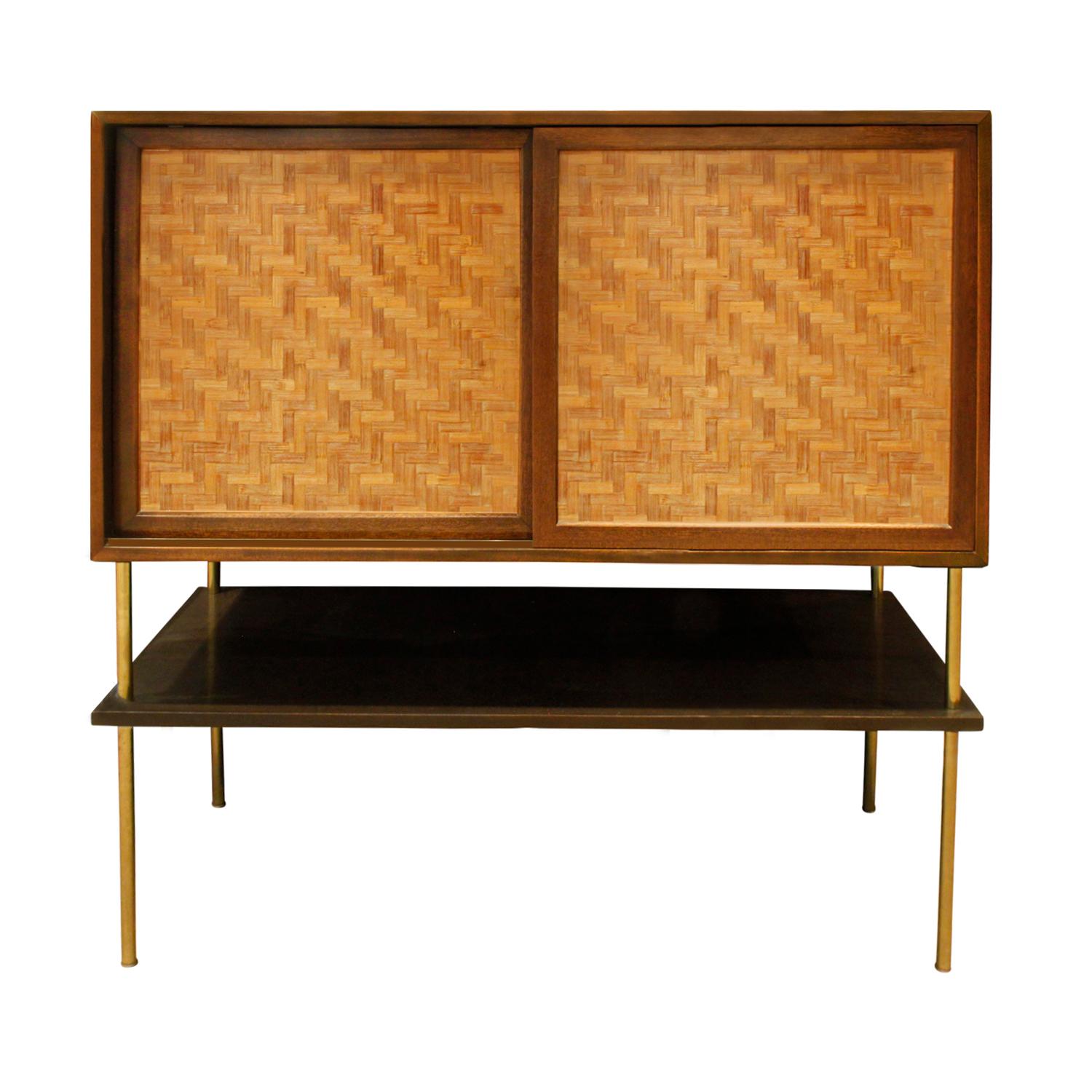 Raised cabinet in mahogany with inset caned doors on brass legs with lower shelf by Harvey Probber, American 1950's. Signed with metal label that reads “Designed by Harvey Probber” located on top interior drawer on right side. The drawers are