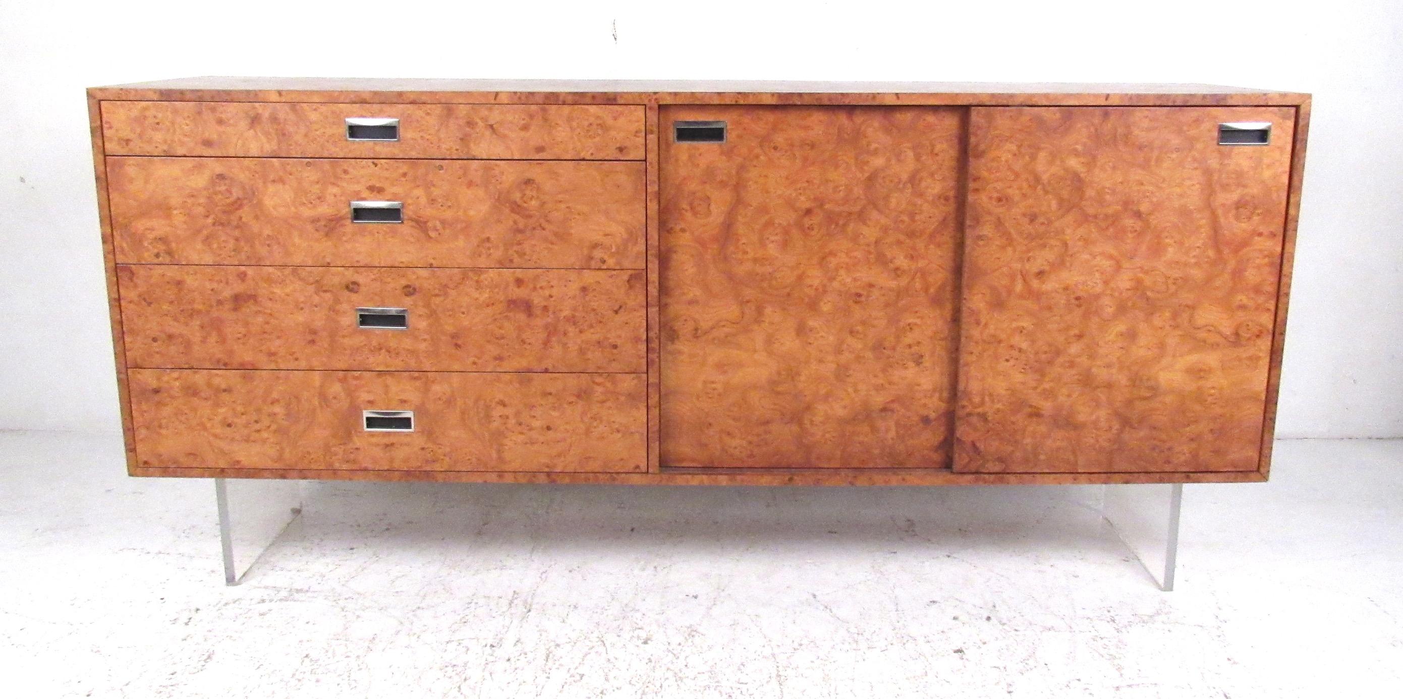 Elegant burl credenza with four storage drawers and two sliding doors which open to a pair of adjustable shelves and four trays. Beautifully detailed, this sleek cabinet is supported on a Lucite slab base giving a floating effect. Please confirm